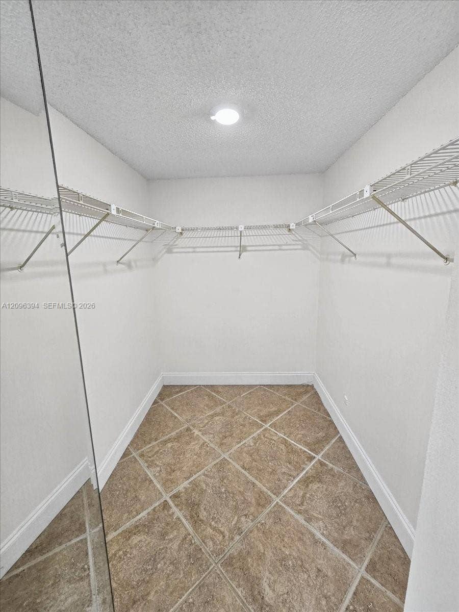 1830 Sabal Palm Drive, #105, Davie, FL 33324 Storage space featuring wall-mounted wire shelving and diagonal-pattern tile flooring