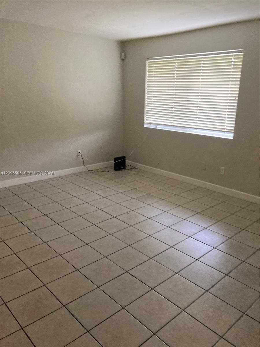 Neutral wall color, ceramic tile flooring, and a window with horizontal blinds