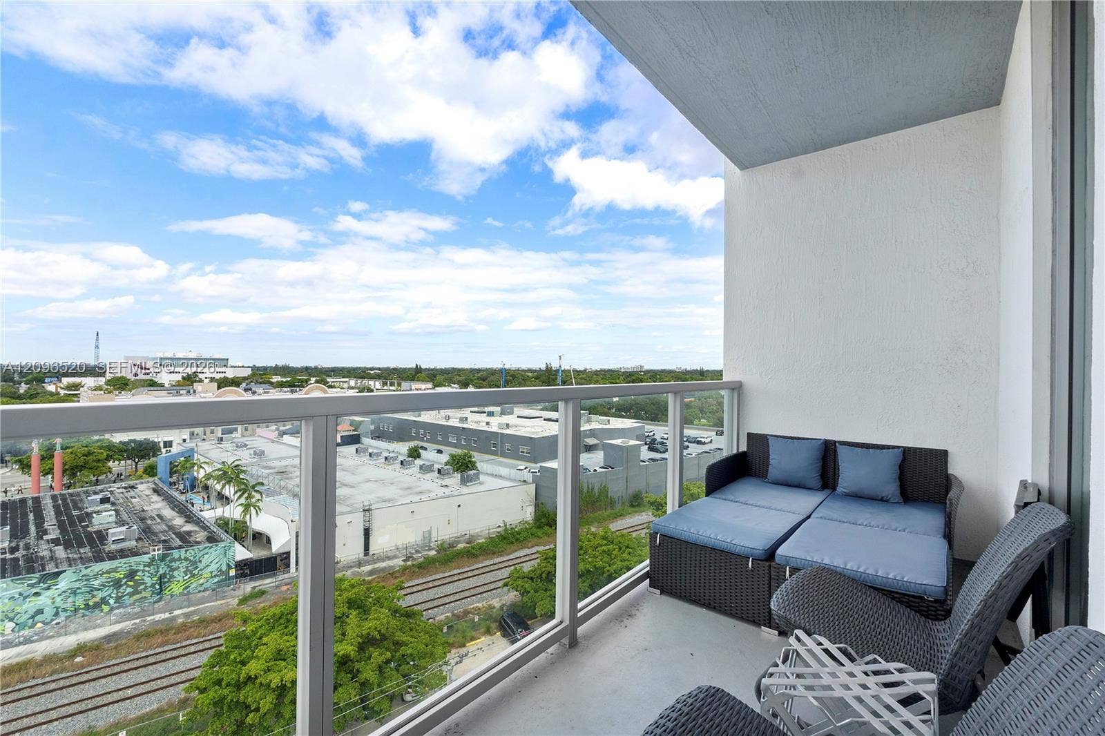 Private balcony featuring a glass-panel railing and concrete flooring