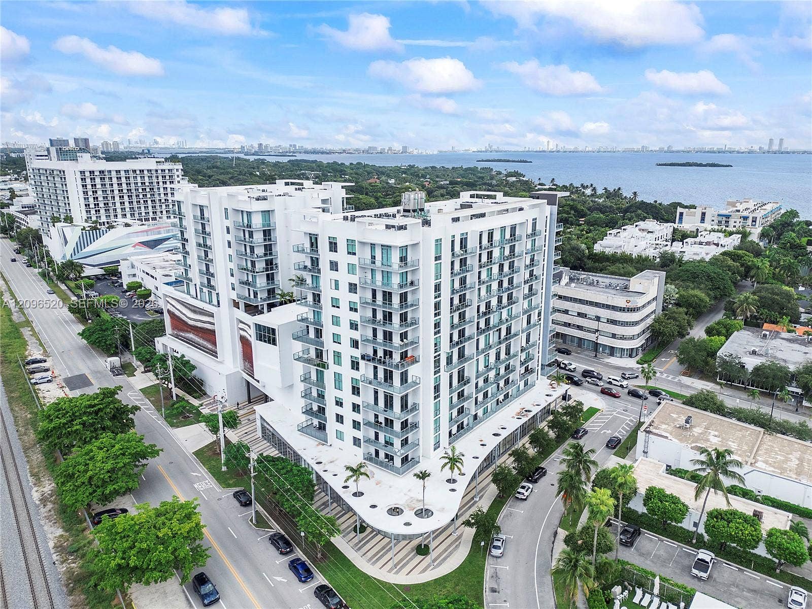 Multi-story residential building featuring glass-paneled balconies, floor-to-ceiling windows, and a structured concrete exterior