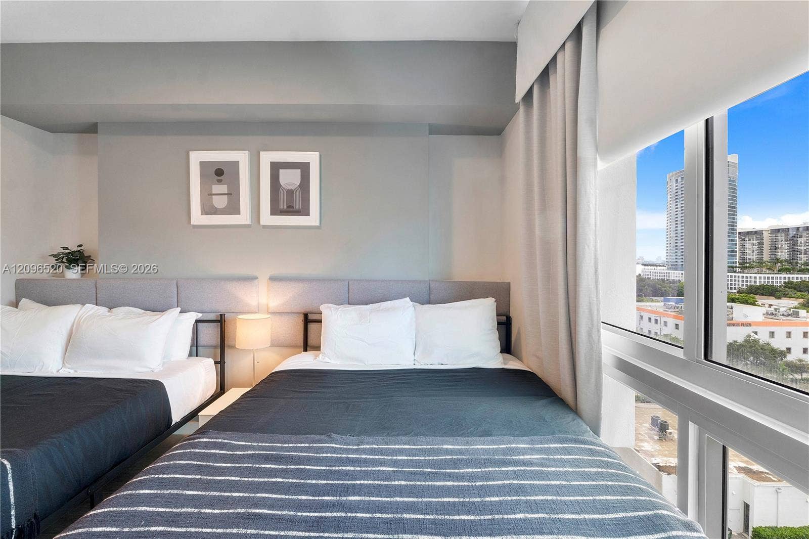 Floor-to-ceiling windows featuring urban scenery and integrated fabric window treatments