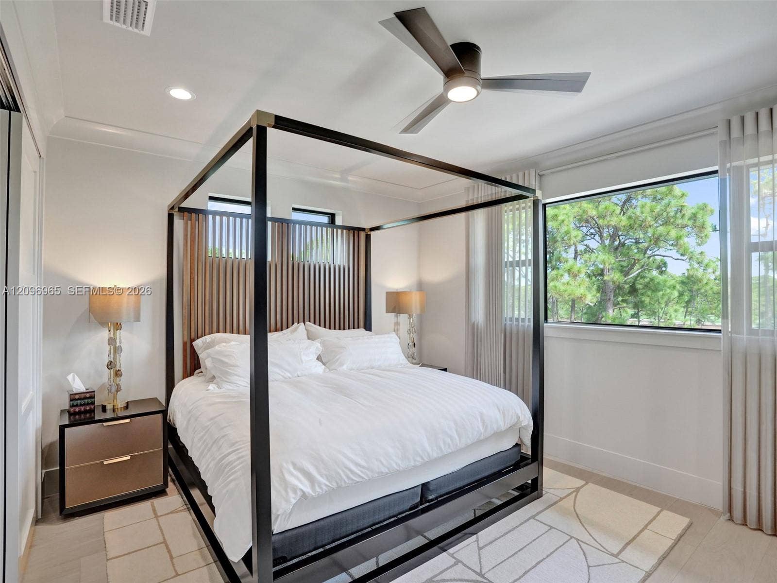 10157 SE Sandpine Lane, Hobe Sound, FL 33455 Bedroom featuring recessed lighting, a multi-blade ceiling fan with integrated lighting, wood-finish flooring, and large windows with horizontal trim