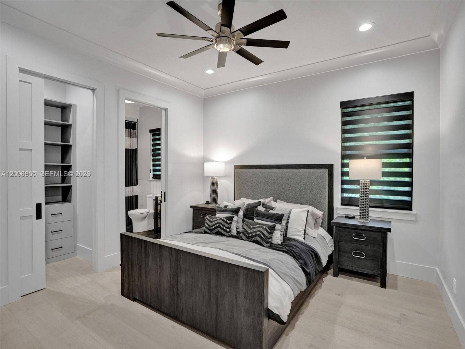 10157 SE Sandpine Lane, Hobe Sound, FL 33455 Light-toned wood-finish flooring, ceiling fan with multi-blade design, recessed lighting, crown molding, and built-in closet cabinetry