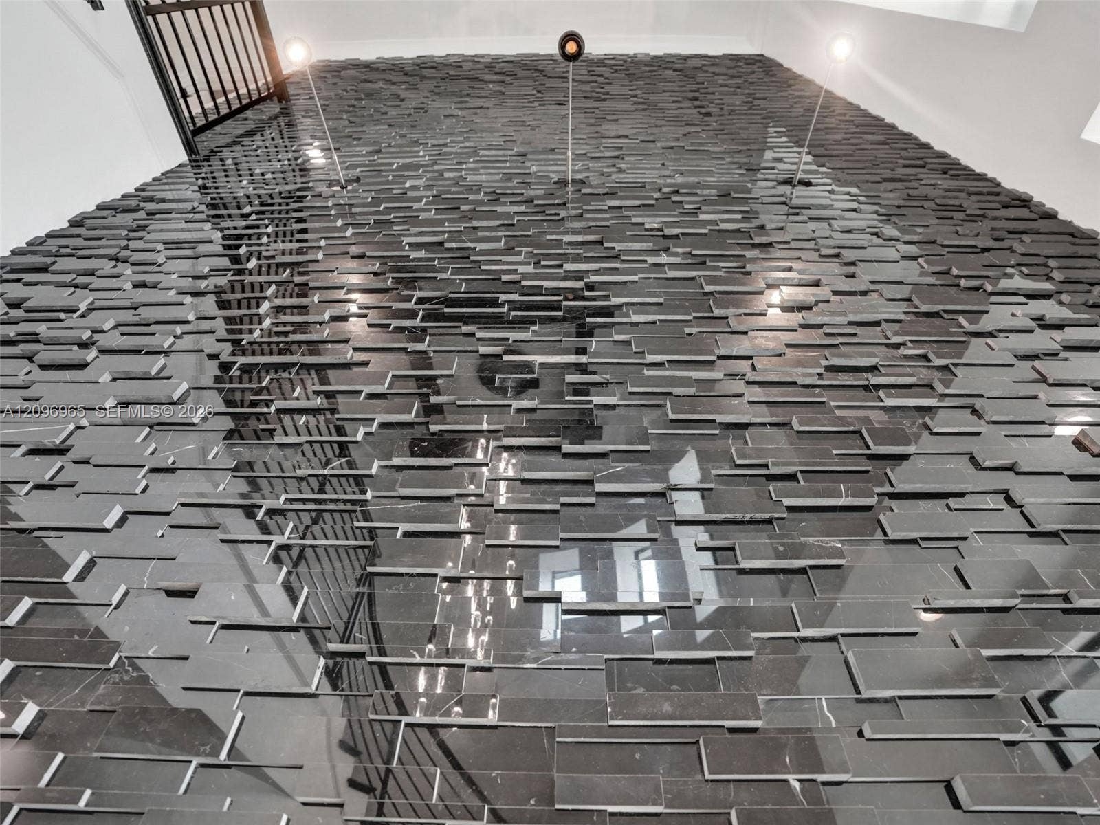 10157 SE Sandpine Lane, Hobe Sound, FL 33455 Floor-to-ceiling accent wall featuring dimensional stone tile in a linear, staggered pattern with integrated adjustable recessed lighting