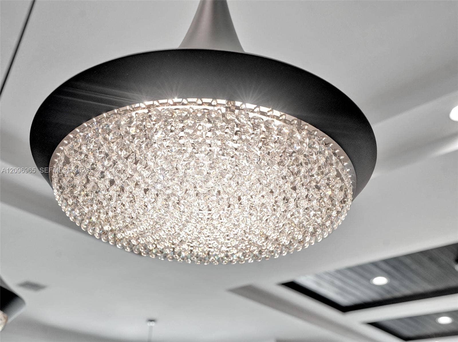 10157 SE Sandpine Lane, Hobe Sound, FL 33455 Contemporary dome pendant light fixture featuring a brushed metallic finish, matte black housing, and multifaceted glass crystal detailing