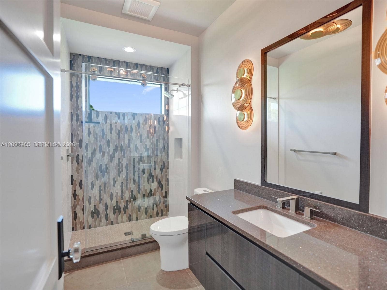 10157 SE Sandpine Lane, Hobe Sound, FL 33455 Modern vanity with a dark-toned flat-panel cabinet, solid-surface countertop, and rectangular undermount sink