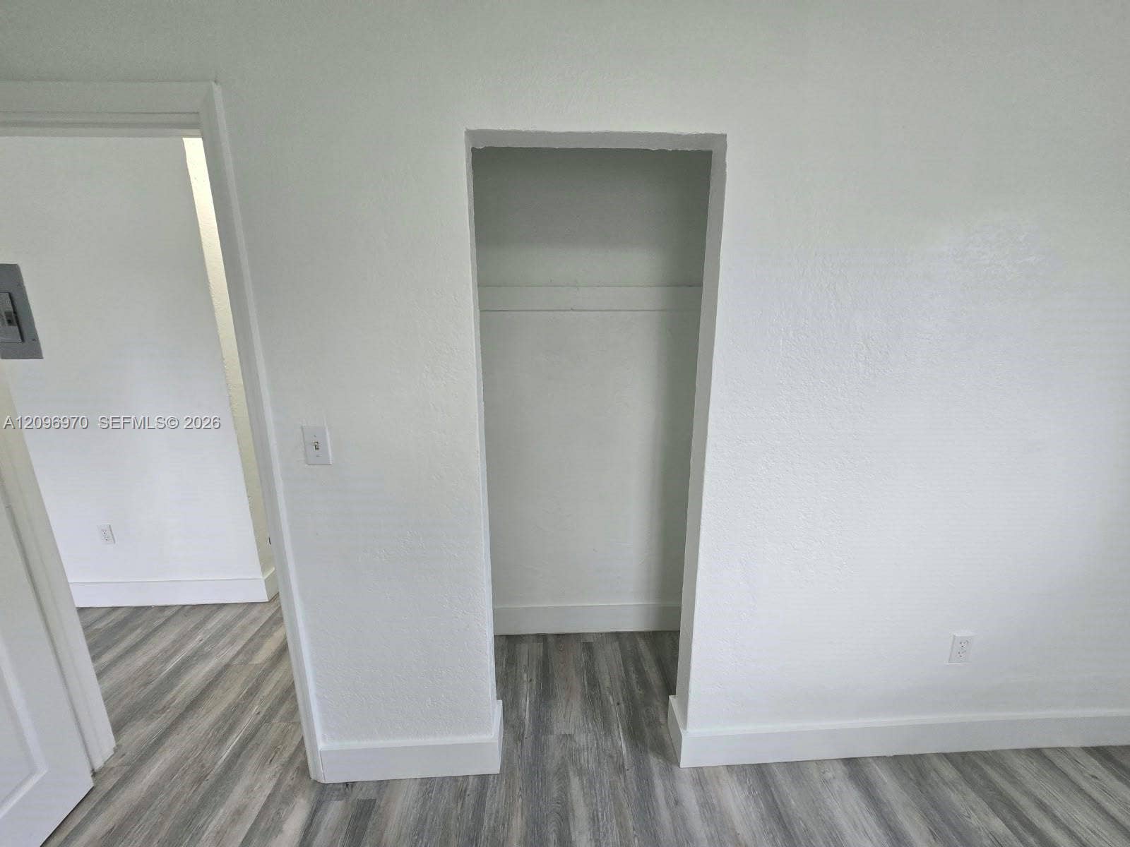 535 NW 7th Street, #12, Miami, Miami, FL 33136 Built-in closet featuring a shelf and rod, complemented by wood-finish flooring and neutral wall tones