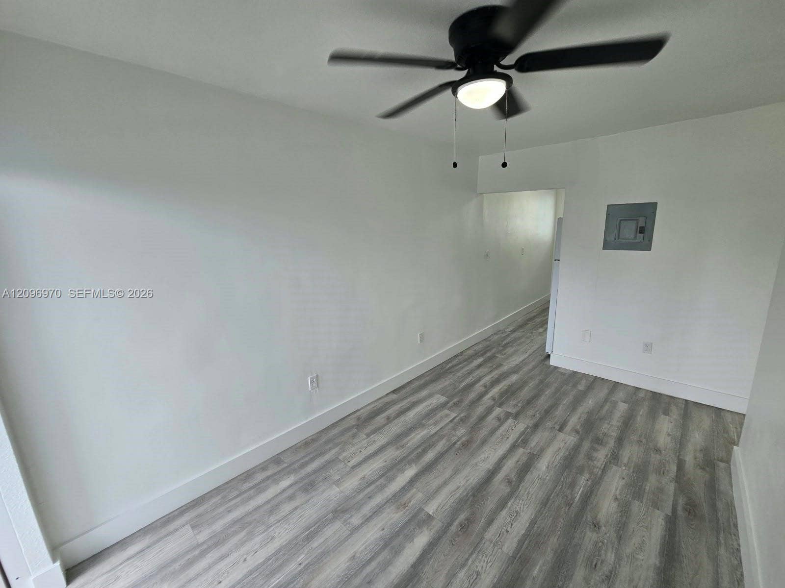 535 NW 7th Street, #12, Miami, Miami, FL 33136 Interior space featuring wood-finish flooring, neutral wall tones, and a ceiling-mounted light fixture with a fan