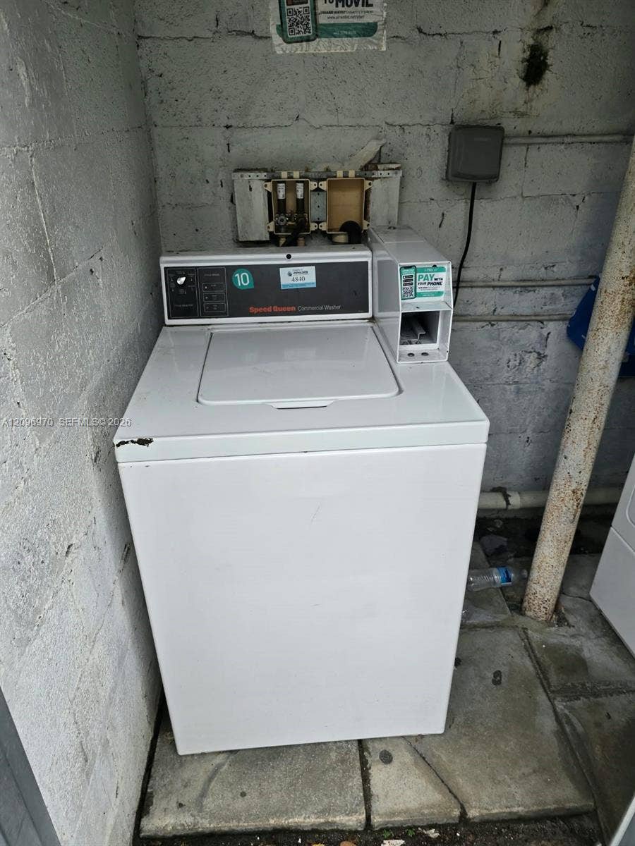 535 NW 7th Street, #12, Miami, Miami, FL 33136 Commercial-grade top-load washing machine featuring a built-in coin-operated payment module and exposed concrete block masonry wall