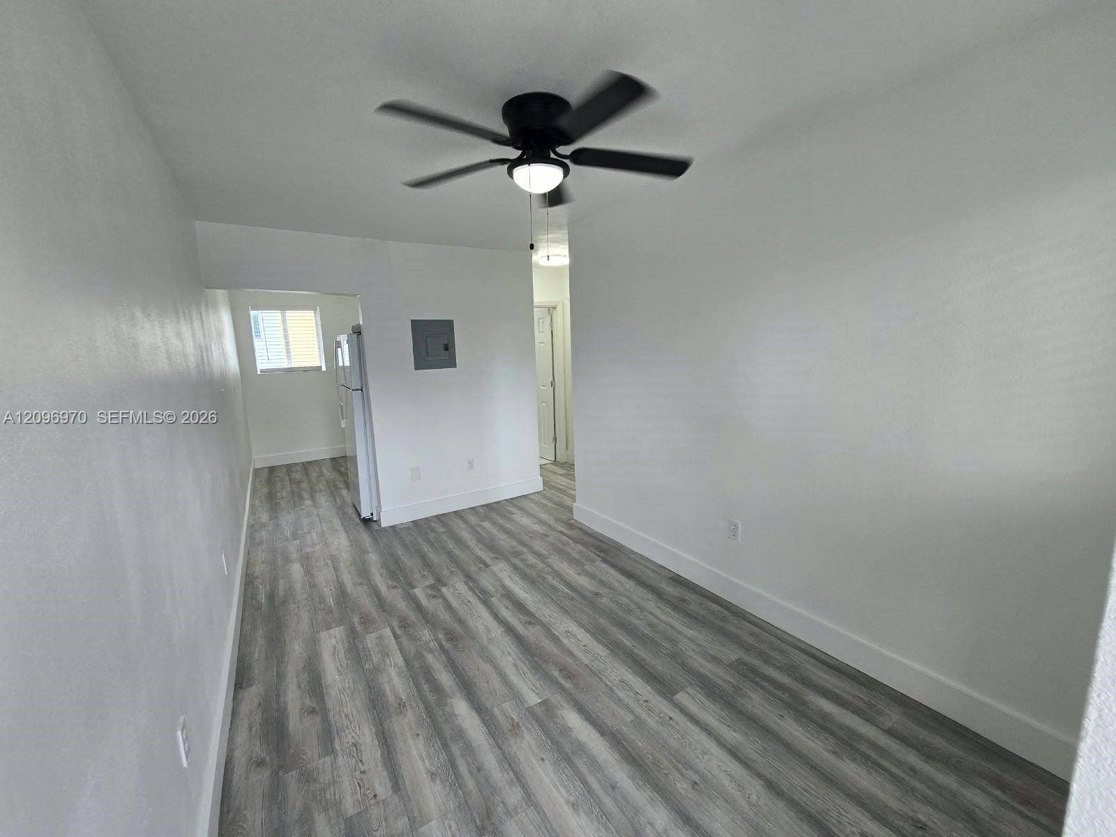 535 NW 7th Street, #12, Miami, Miami, FL 33136 Interior space featuring wood-finish flooring, white walls, and a ceiling fan with integrated lighting
