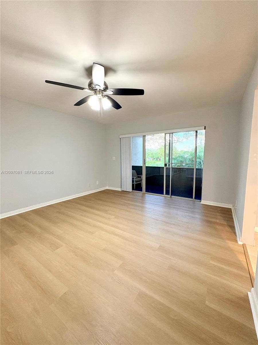 3271 Coral Springs Drive, #2, Coral Springs, Coral Springs, FL 33065 Wood-finish flooring, ceiling fan with integrated lighting, and sliding glass doors with vertical blinds