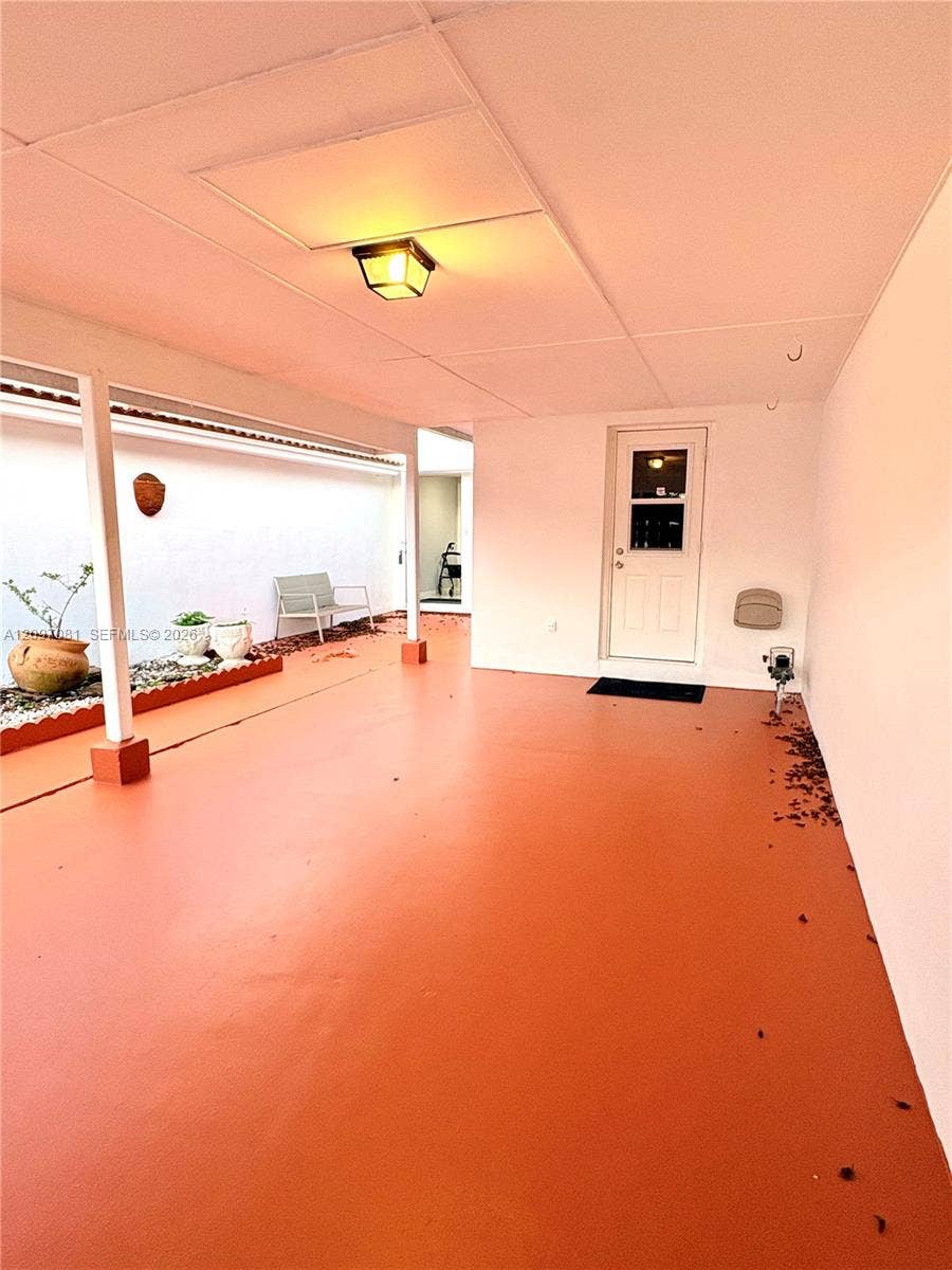 3271 Coral Springs Drive, #2, Coral Springs, Coral Springs, FL 33065 Covered patio featuring a solid-surface floor, recessed lighting, and a garden bed bordered by decorative stone