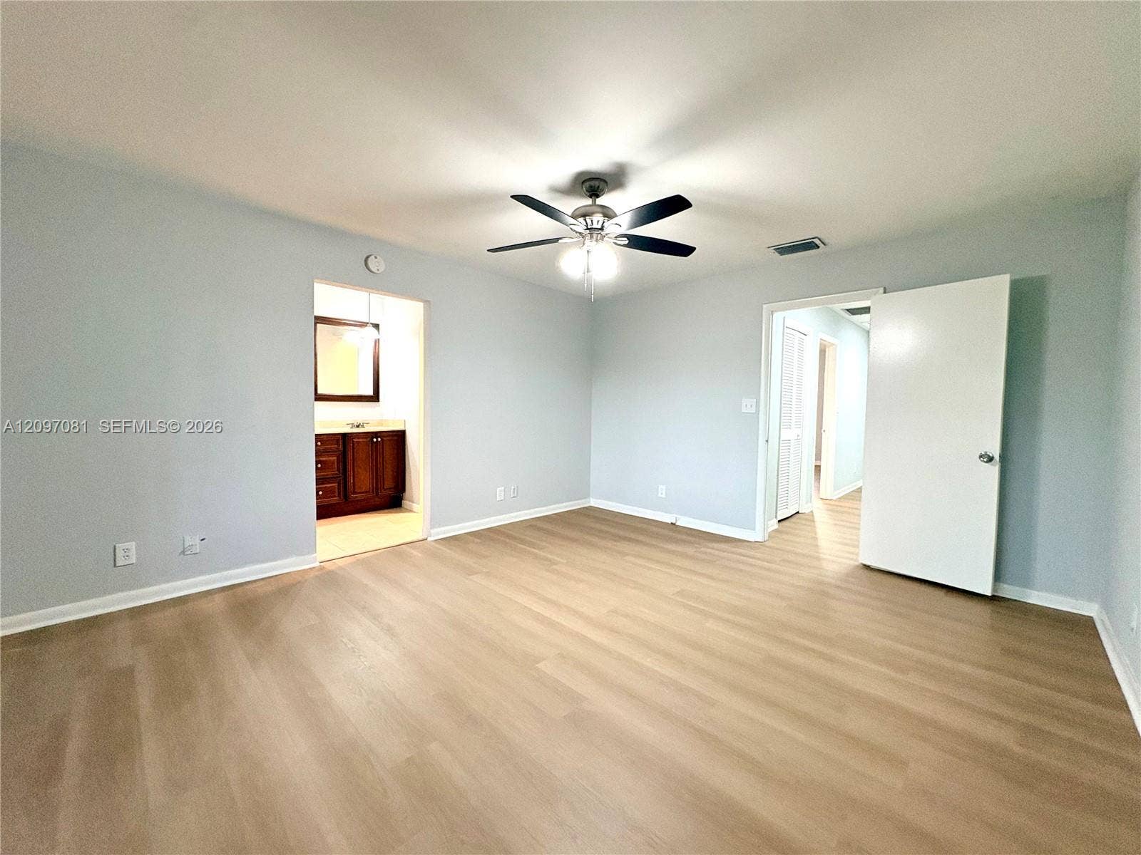 3271 Coral Springs Drive, #2, Coral Springs, Coral Springs, FL 33065 Neutral-toned interior featuring wood-finish flooring, a ceiling fan with integrated lighting, and solid-core doors