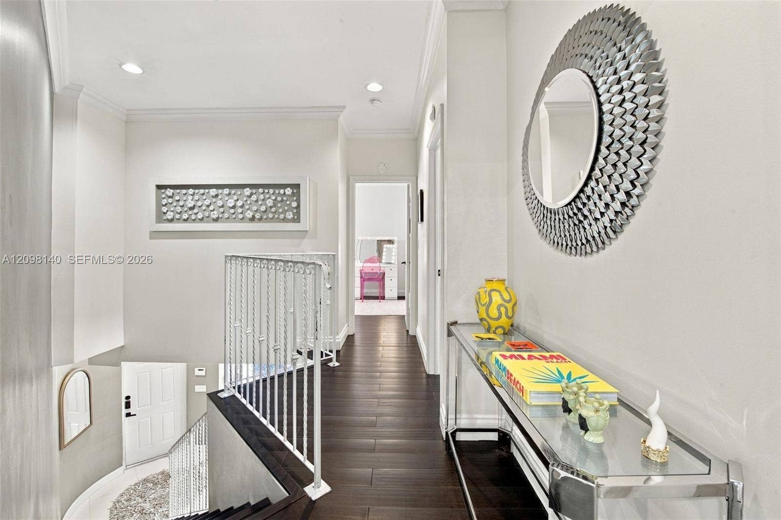 Hallway featuring dark wood-finish flooring, recessed lighting, and white ornamental stair railing