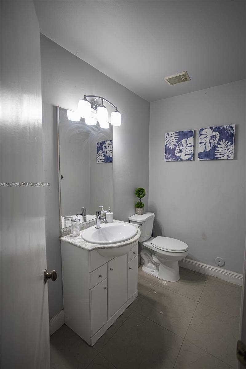 Guest bathroom with a white vanity and simple, timeless finishes.