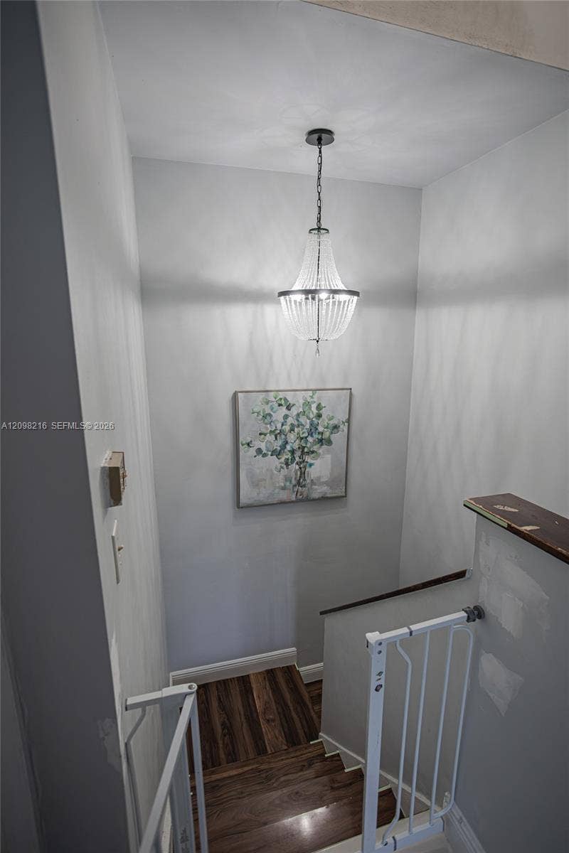 Upstairs landing with a pendant light and an open railing.