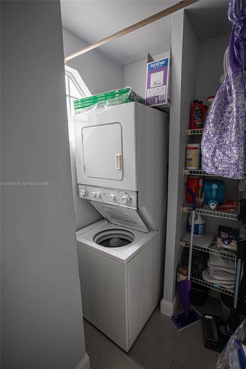 Interior laundry closet with a stacked washer and dryer.