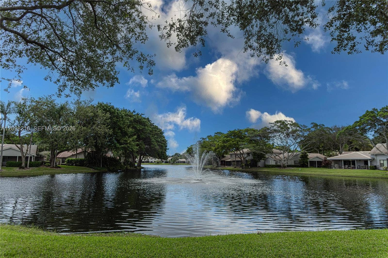 Tranquil lake view with a fountain, just steps from home.