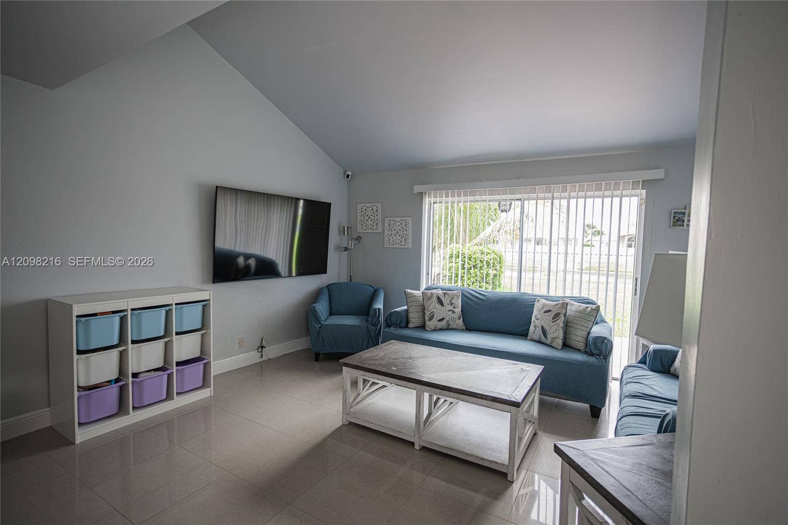 Vaulted ceilings and a wall of windows fill the living room with soft natural light.