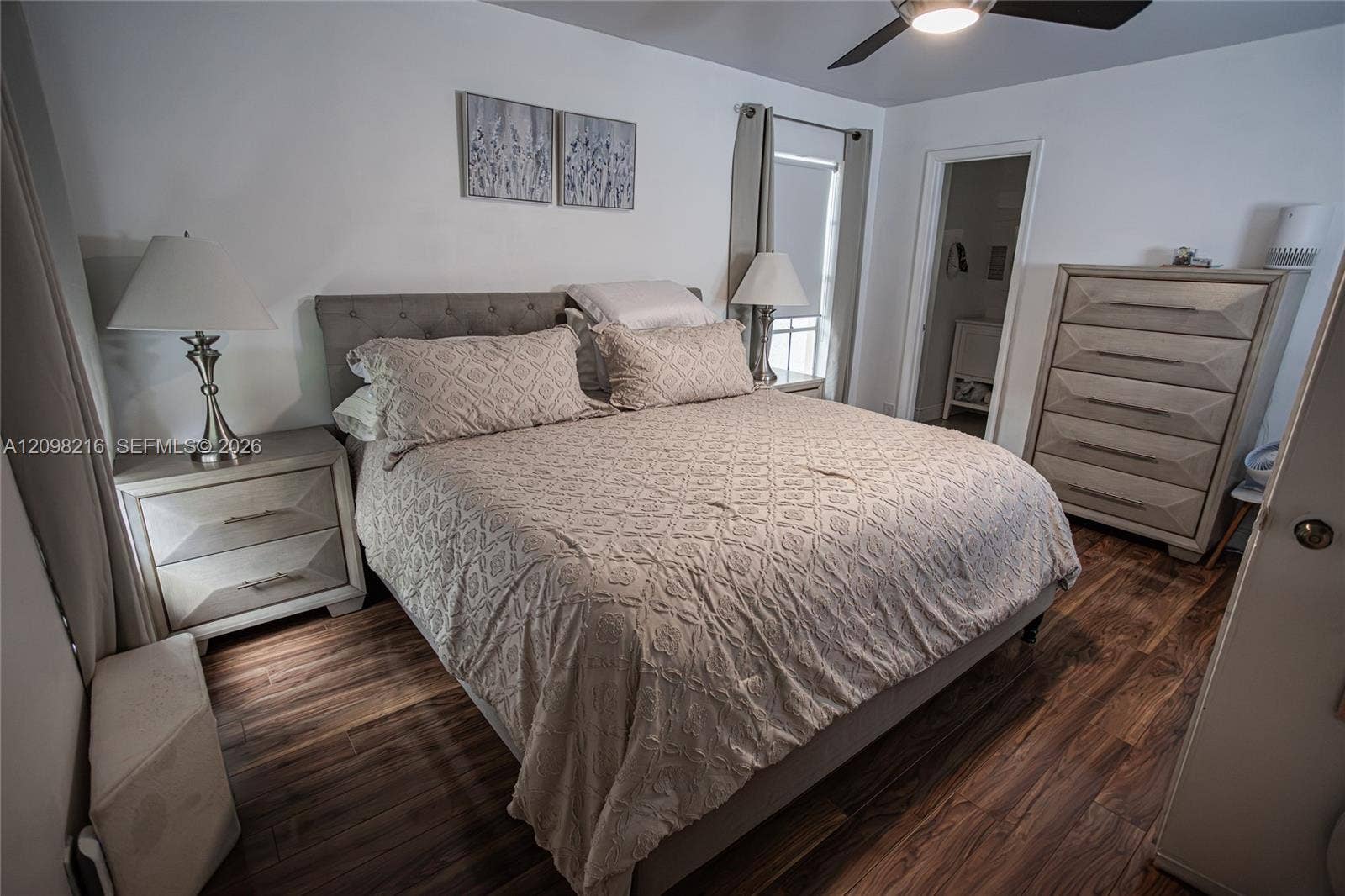 Serene bedroom with wood style flooring, a ceiling fan and room for a full furniture suite.