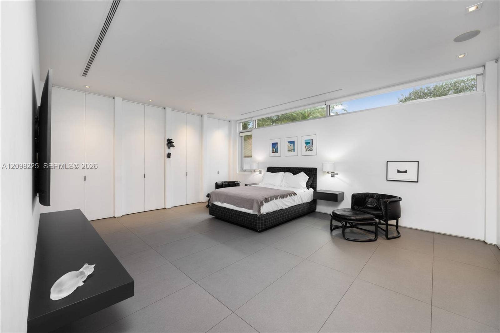 Expansive room featuring large-format tile flooring, built-in floor-to-ceiling storage cabinetry, recessed lighting, and horizontal clerestory windows