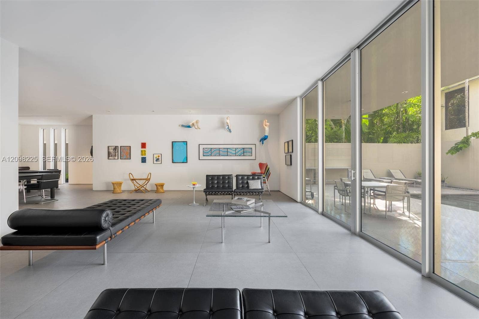 Open-concept interior featuring large-format tile flooring, floor-to-ceiling glass walls, and recessed lighting