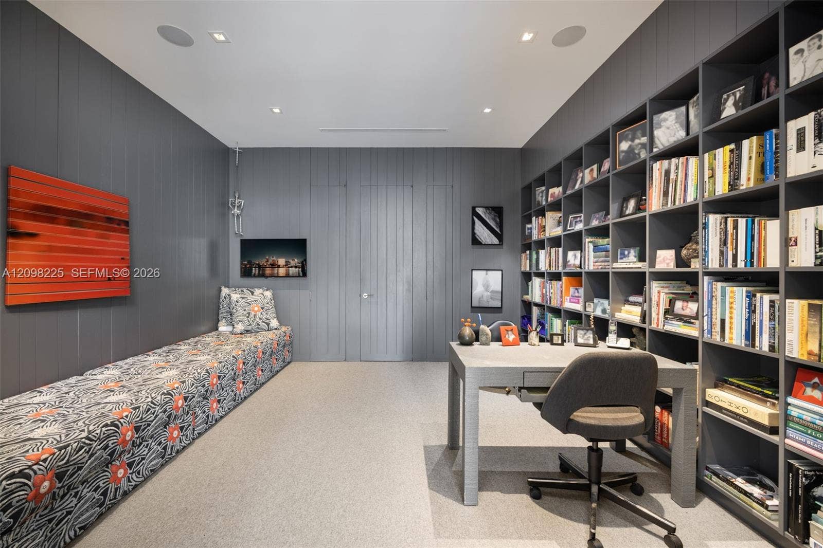Built-in floor-to-ceiling shelving, recessed ceiling lighting, and custom wood-paneled walls