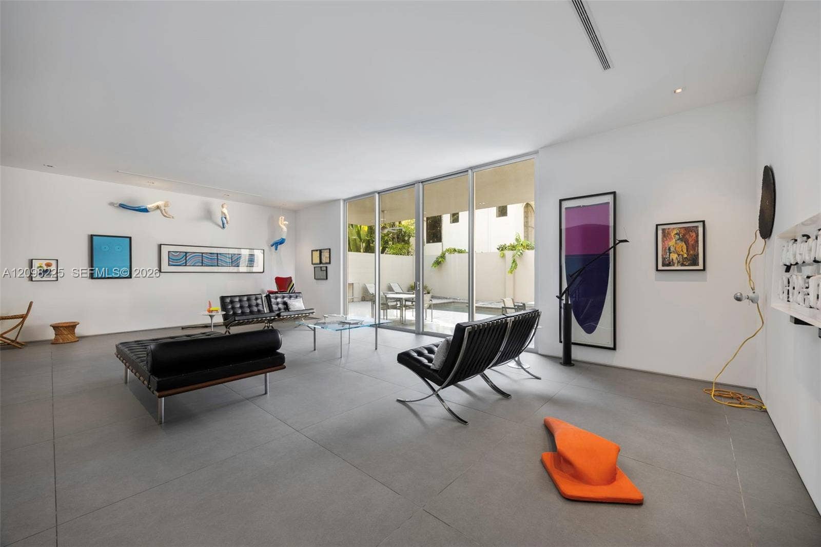 Large-format tile flooring, floor-to-ceiling glass sliding doors, recessed lighting, and smooth white walls