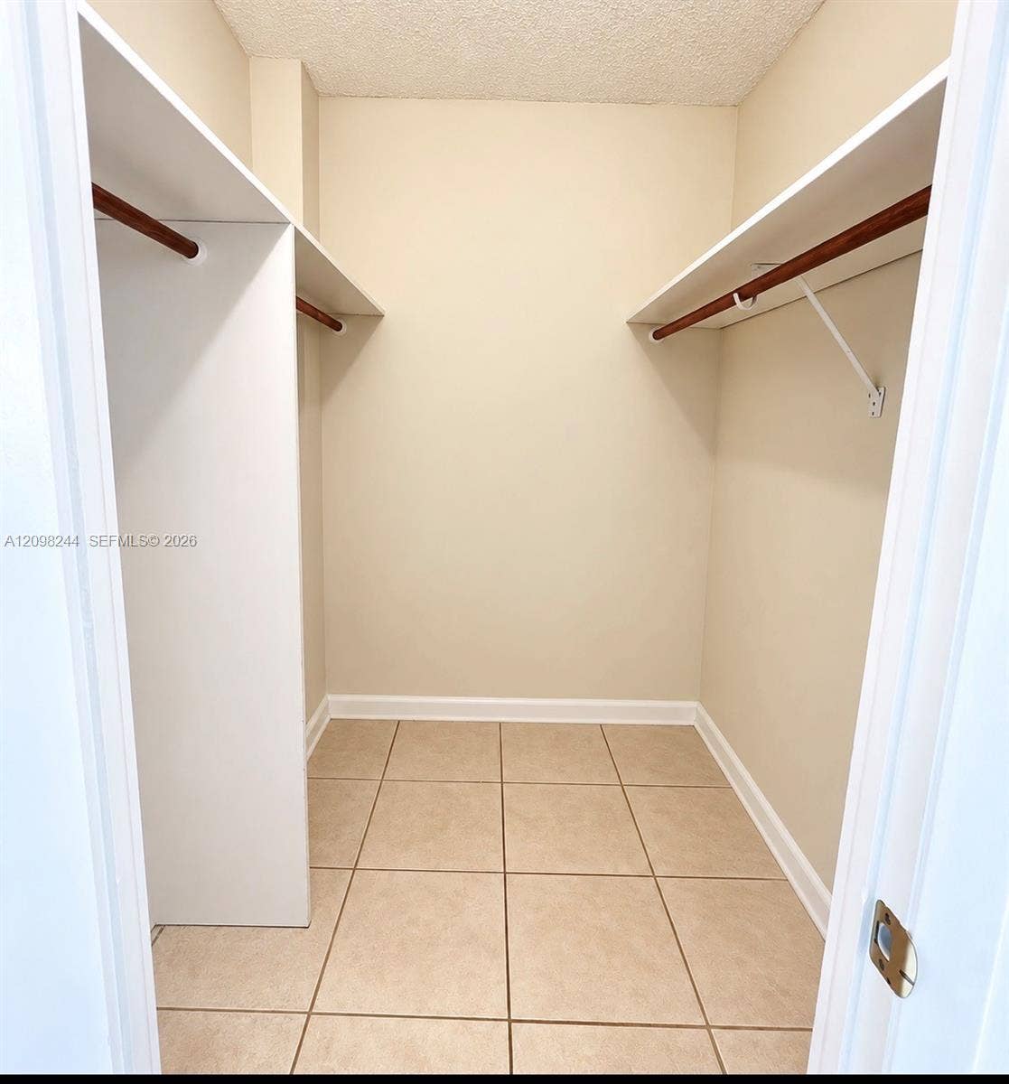 2851 NE 183rd Street, #2110E, Aventura, Aventura, FL 33160 Storage closet featuring ceramic tile flooring, dual-level white shelving, and wood-finish hanging rods