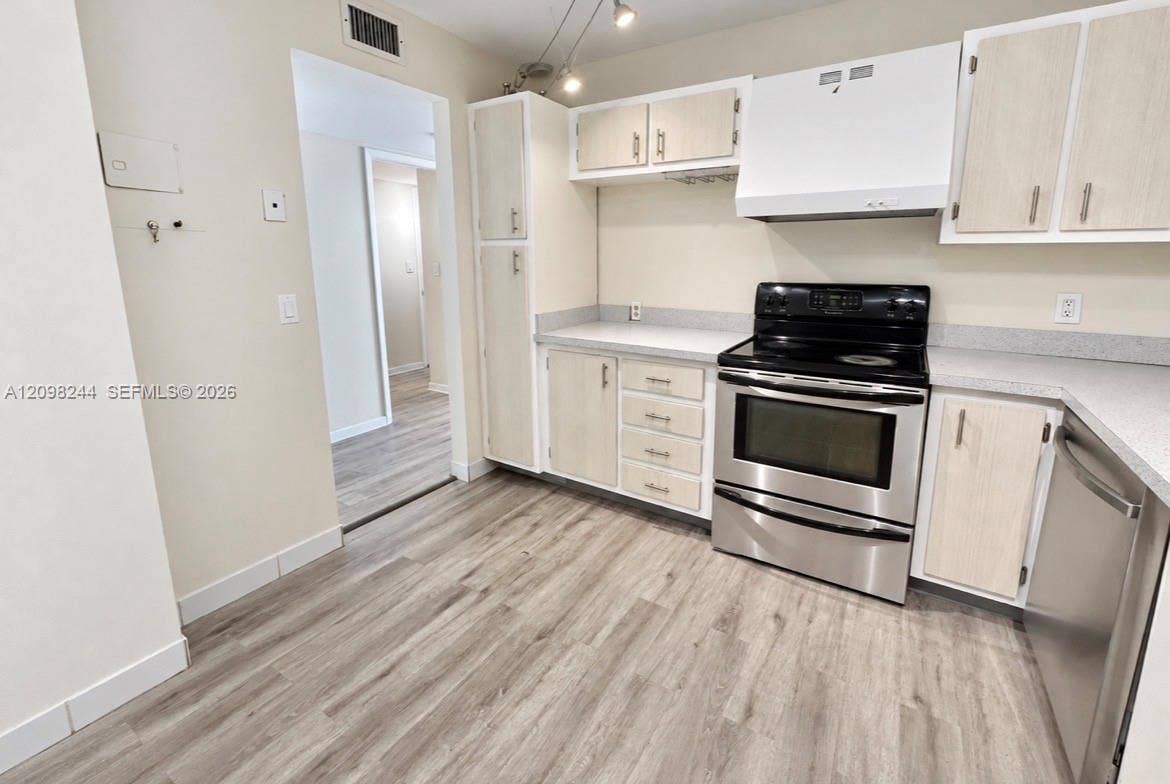 2851 NE 183rd Street, #2110E, Aventura, Aventura, FL 33160 Kitchen featuring light-toned cabinetry, solid surface countertops, stainless steel appliances, and wood-finish flooring
