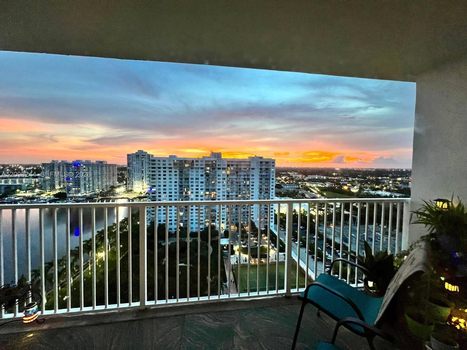 2851 NE 183rd Street, #2110E, Aventura, Aventura, FL 33160 Covered balcony featuring white vertical railing, tile flooring, and water-front cityscape backdrop