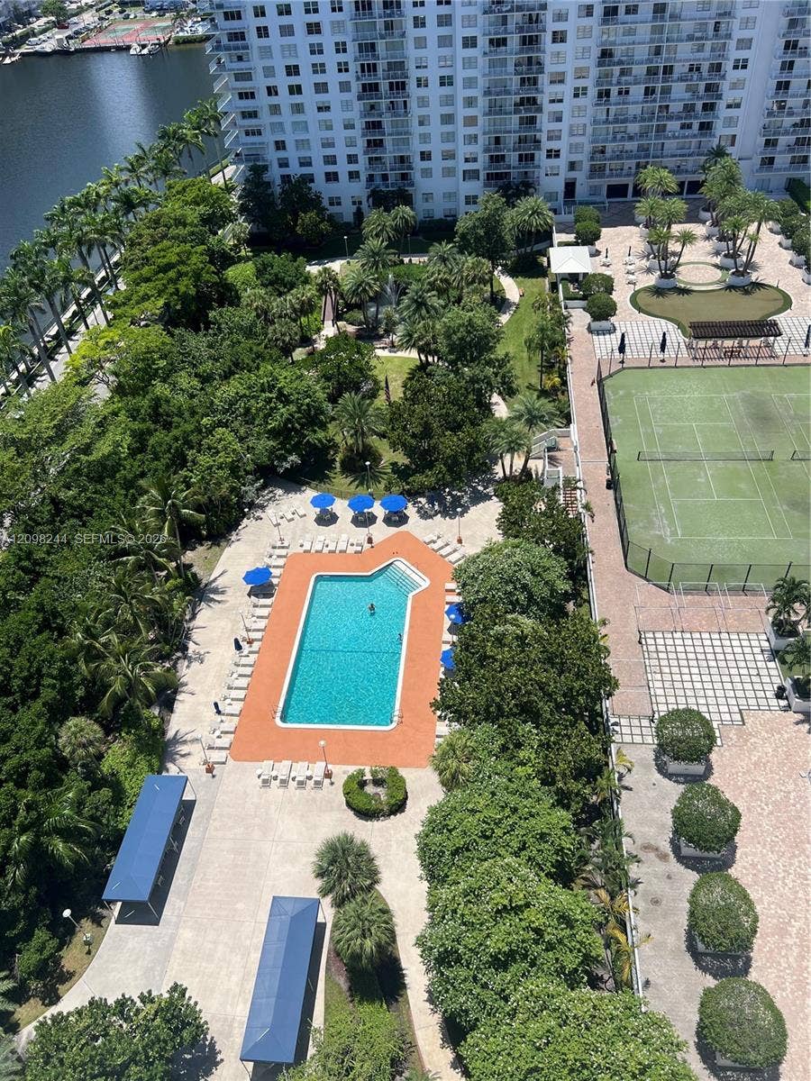 2851 NE 183rd Street, #2110E, Aventura, Aventura, FL 33160 Community recreation area featuring a swimming pool, tennis court, manicured green space, and mature trees