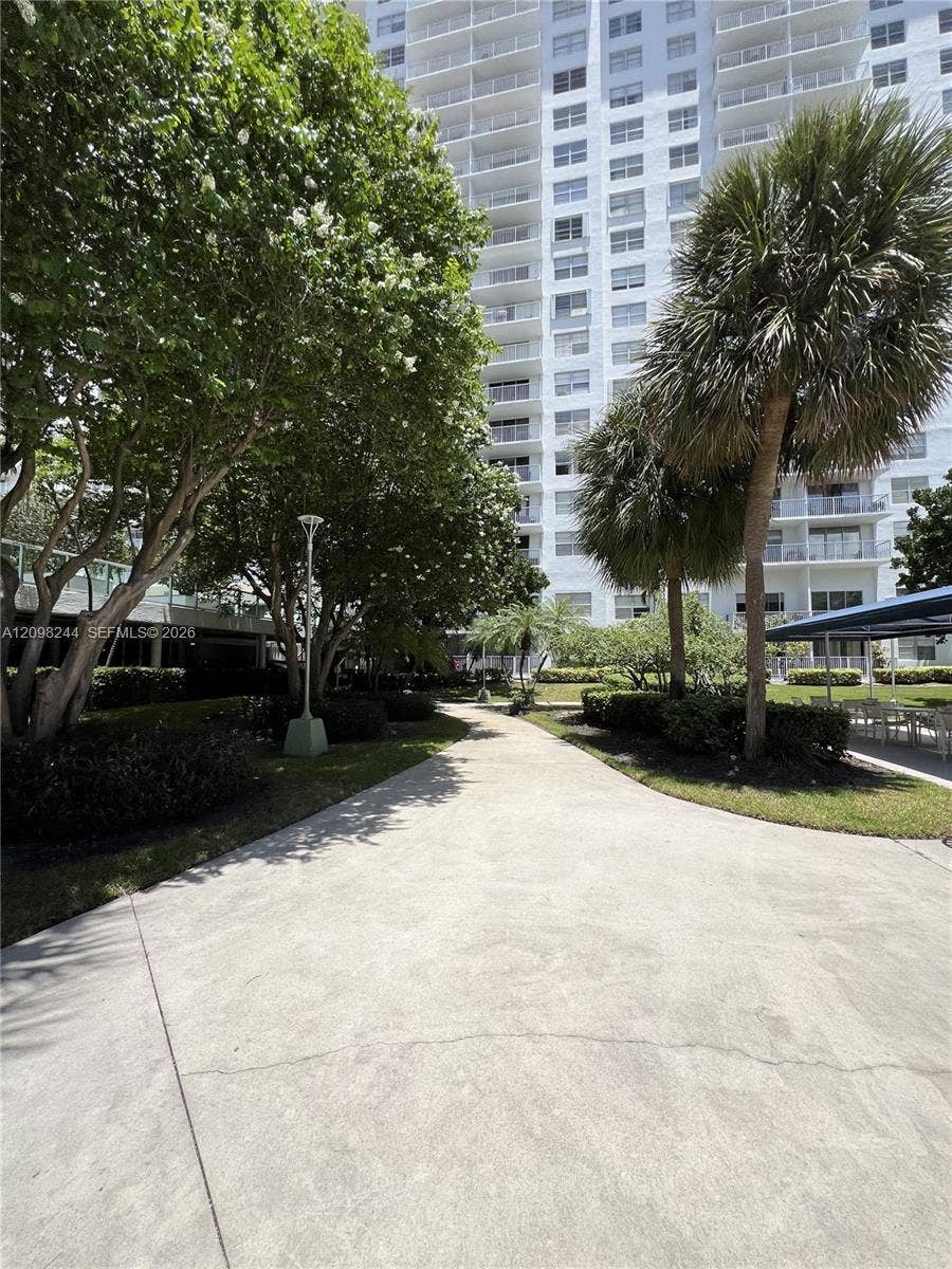 2851 NE 183rd Street, #2110E, Aventura, Aventura, FL 33160 Paved walkway surrounded by mature trees, palm trees, manicured landscaping, and exterior pole lighting