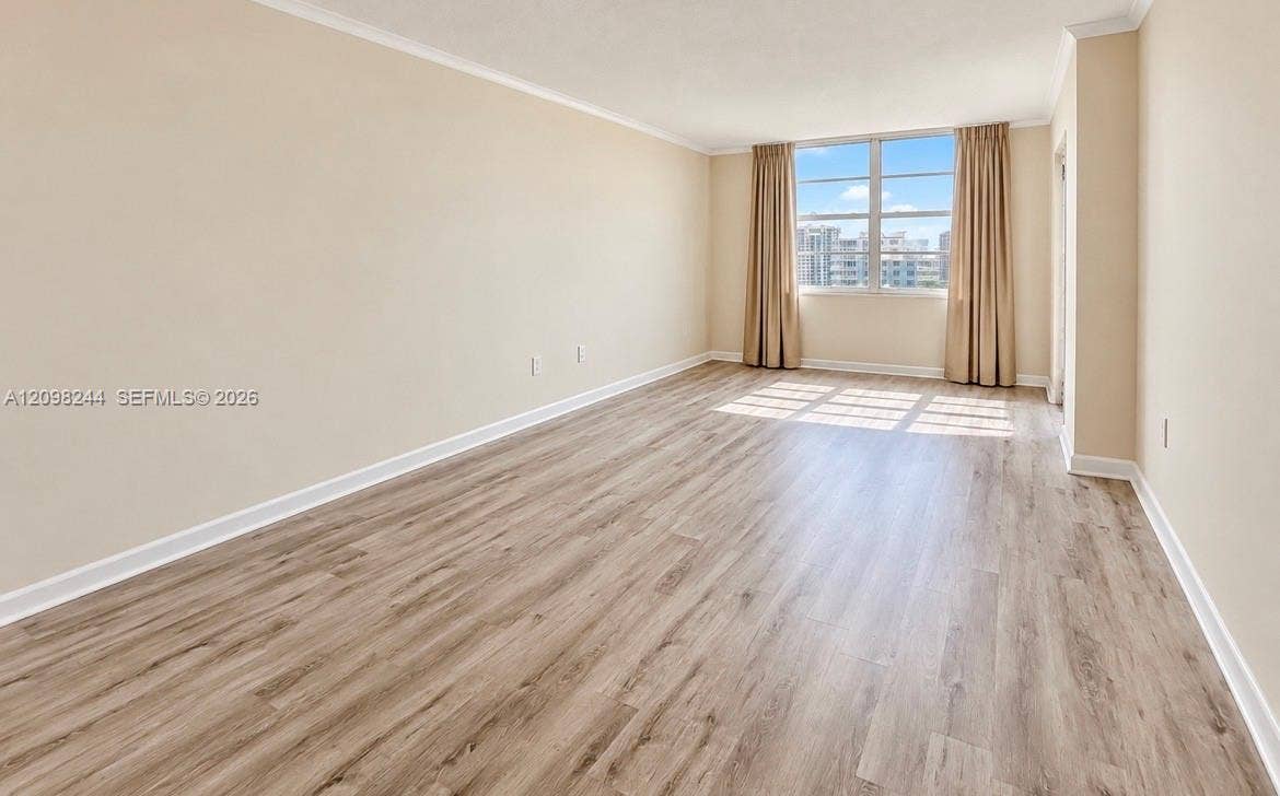 2851 NE 183rd Street, #2110E, Aventura, Aventura, FL 33160 Spacious room featuring wood-finish flooring, neutral wall paint, and a large multi-pane window