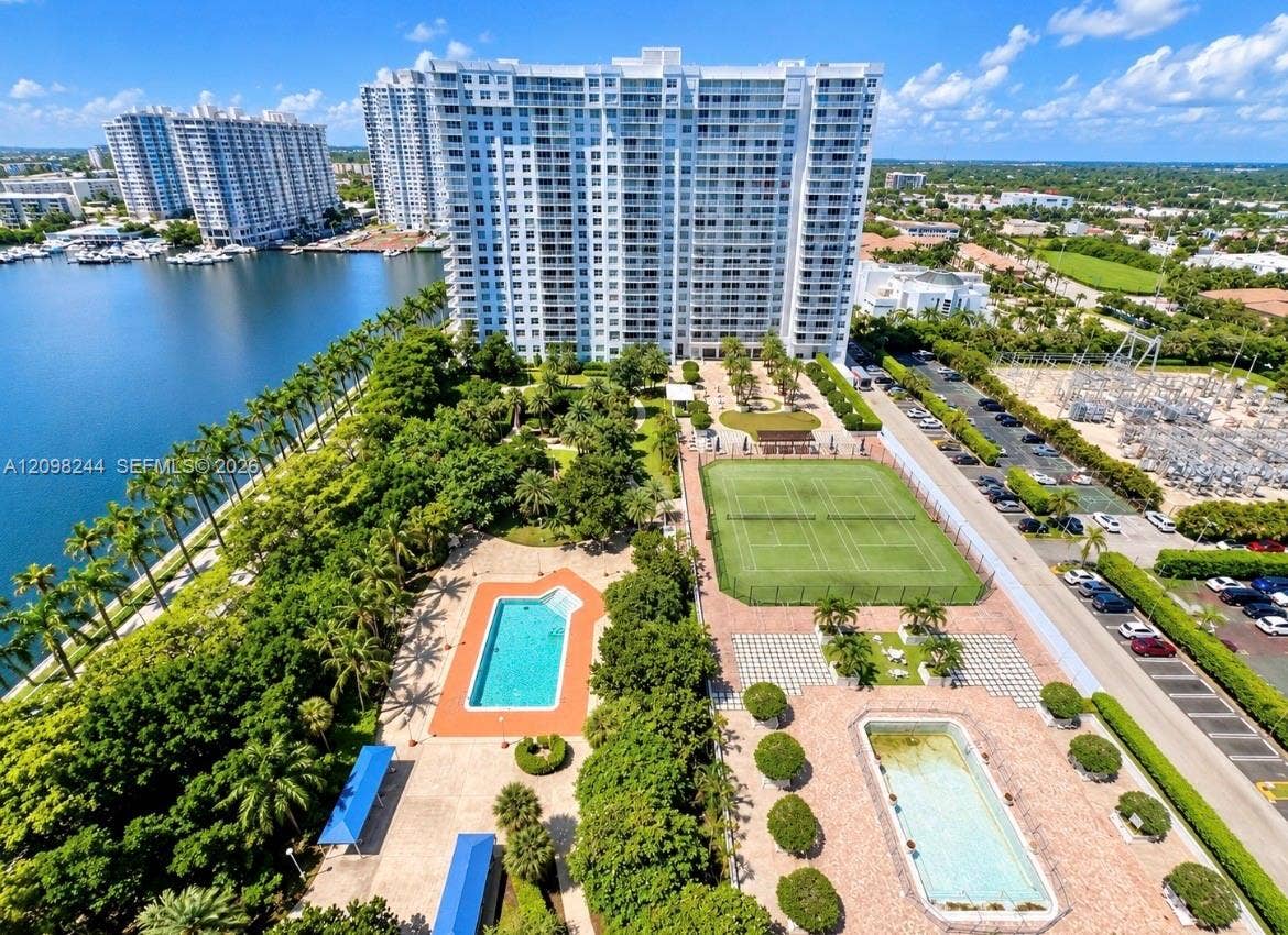 2851 NE 183rd Street, #2110E, Aventura, Aventura, FL 33160 High-rise residential building featuring multiple swimming pools, a tennis court, landscaped grounds, and water frontage