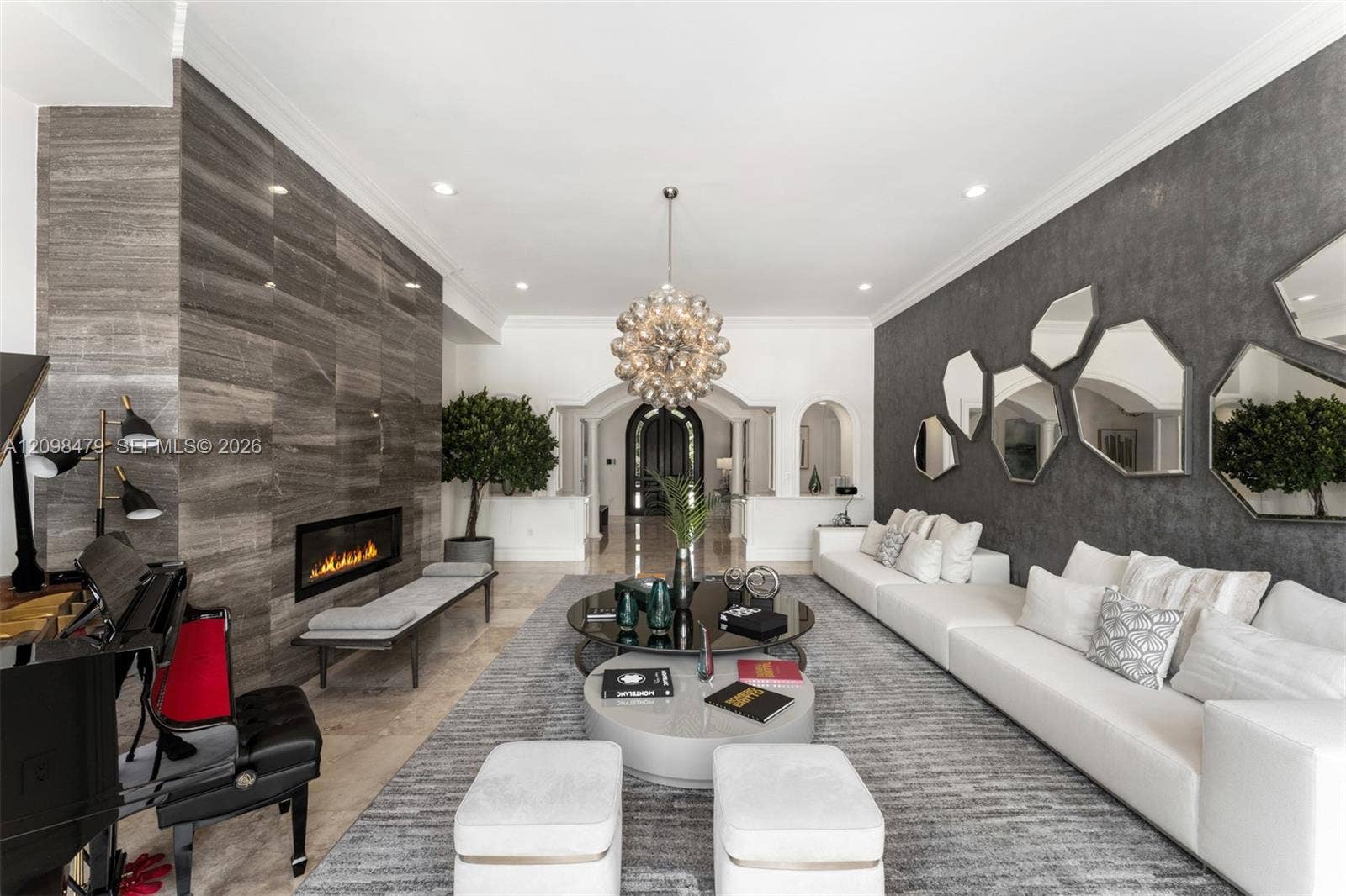 Recessed lighting illuminates a long wall featuring a linear fireplace and stone-finish paneling