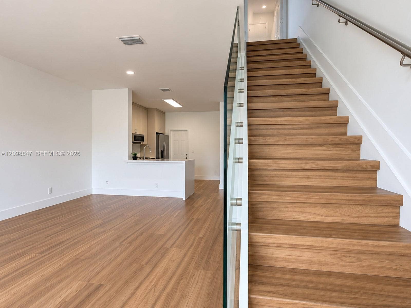 3818 San Simeon Circle, #3818, Weston, Weston, FL 33331 Modern staircase featuring wood-finish steps and glass panel railings leading up to the bedrooms.