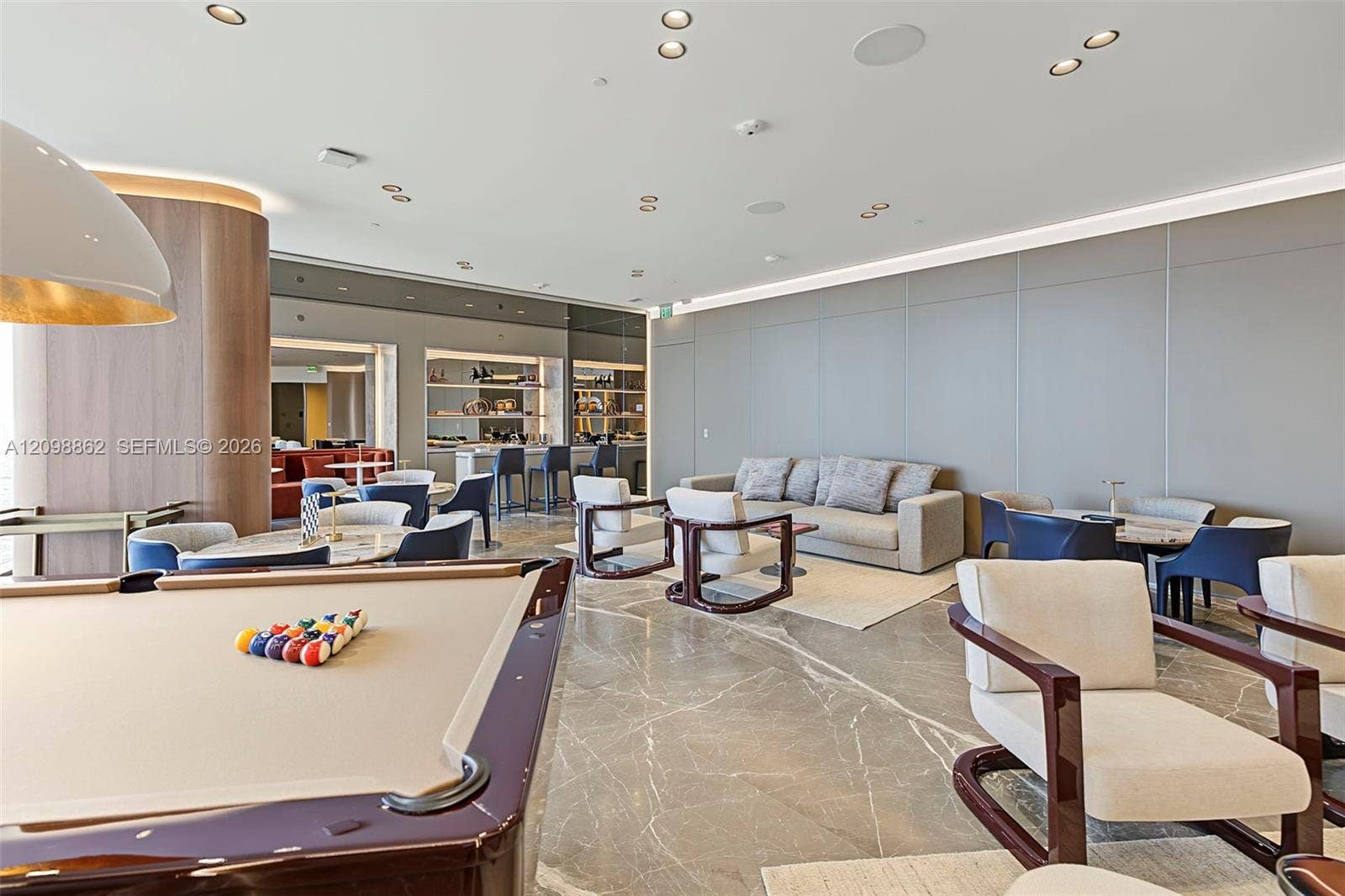 Common area featuring large-format stone flooring, recessed ceiling lighting with cove illumination, and built-in cabinetry with integrated shelving