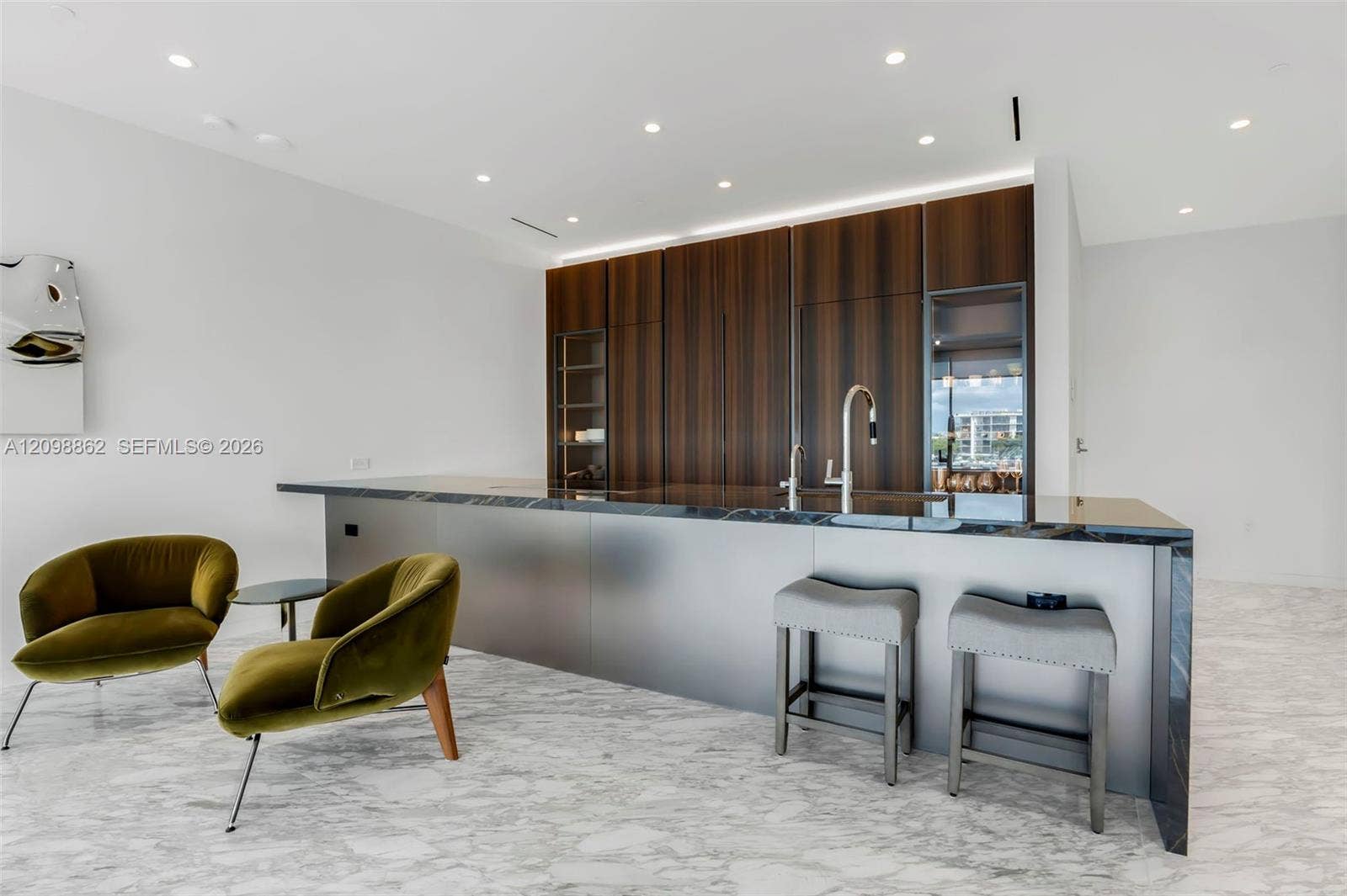 Kitchen featuring dark wood-finish cabinetry, a large center island with stone countertop, stainless steel integrated sink, and recessed ceiling lighting