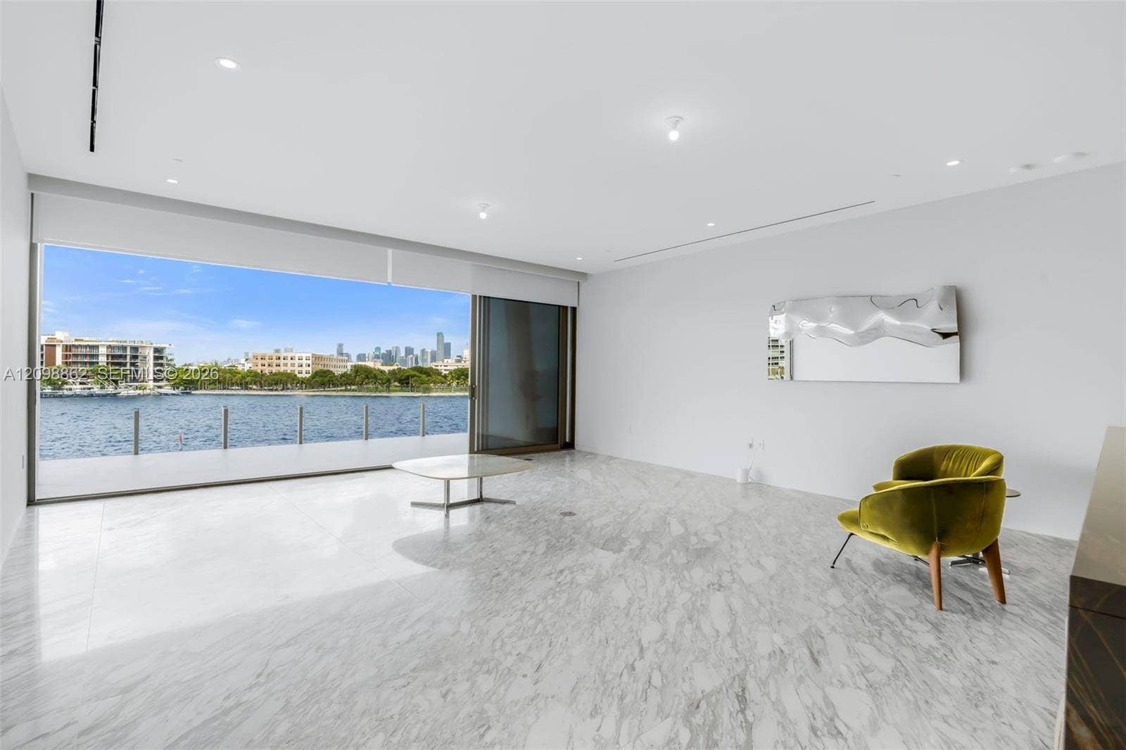 Large-format tile flooring, expansive sliding glass doors, recessed lighting, and water-fronting balcony