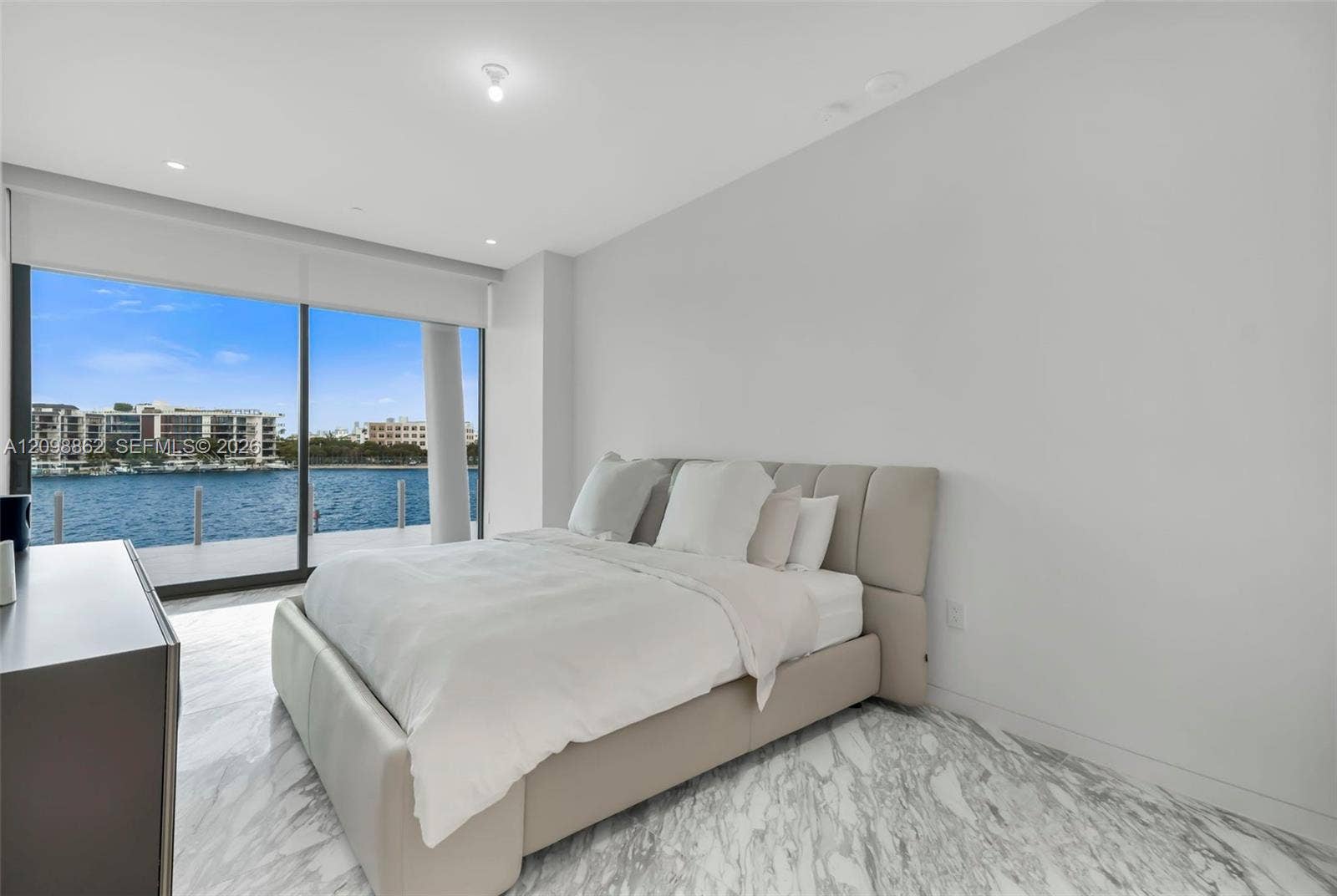 Floor-to-ceiling sliding glass doors, stone-finish flooring, and recessed ceiling lighting