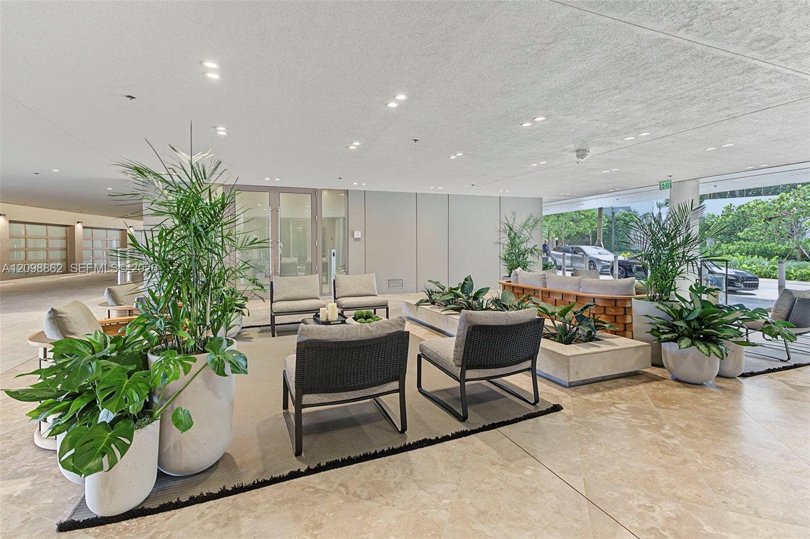 Covered open-air entrance featuring stone flooring, recessed ceiling lighting, and integrated concrete planters