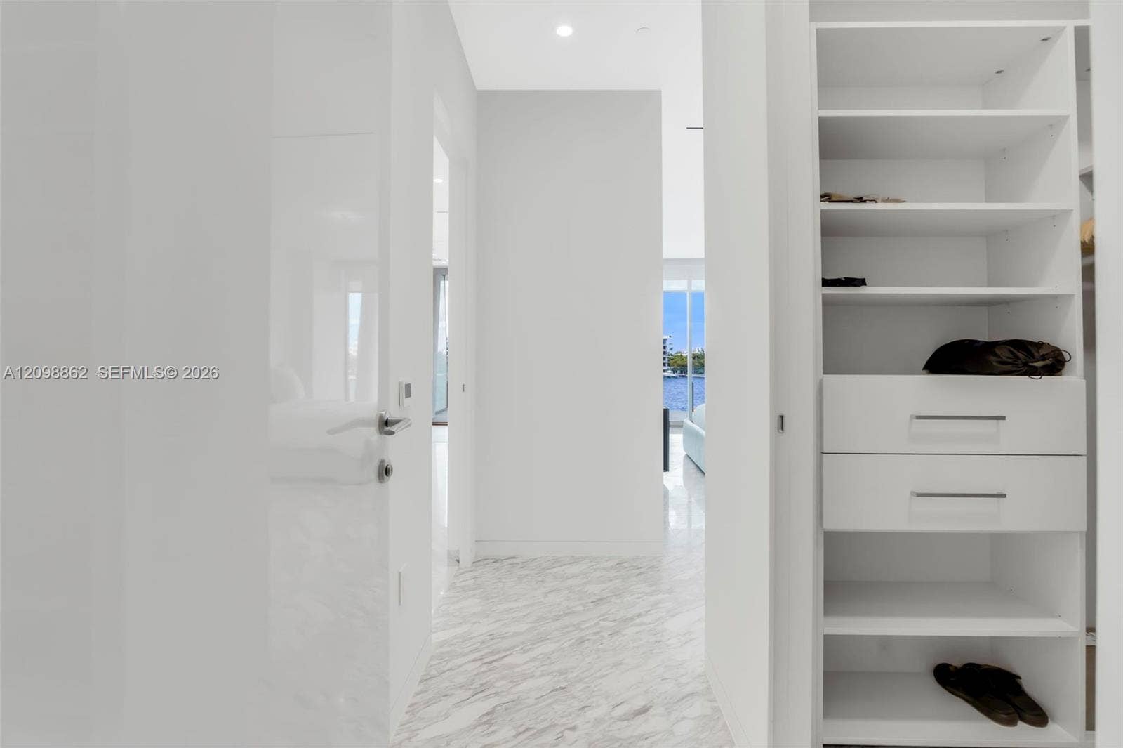 Built-in storage system with shelving and drawers, polished stone flooring, and recessed ceiling lighting