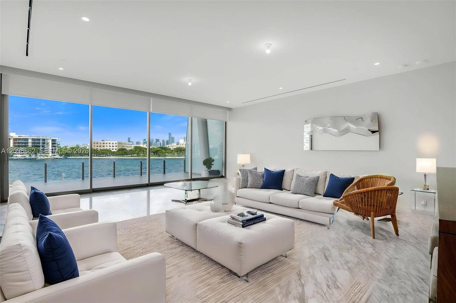Floor-to-ceiling glass wall, polished tile flooring, recessed ceiling lighting, and waterfront scenery