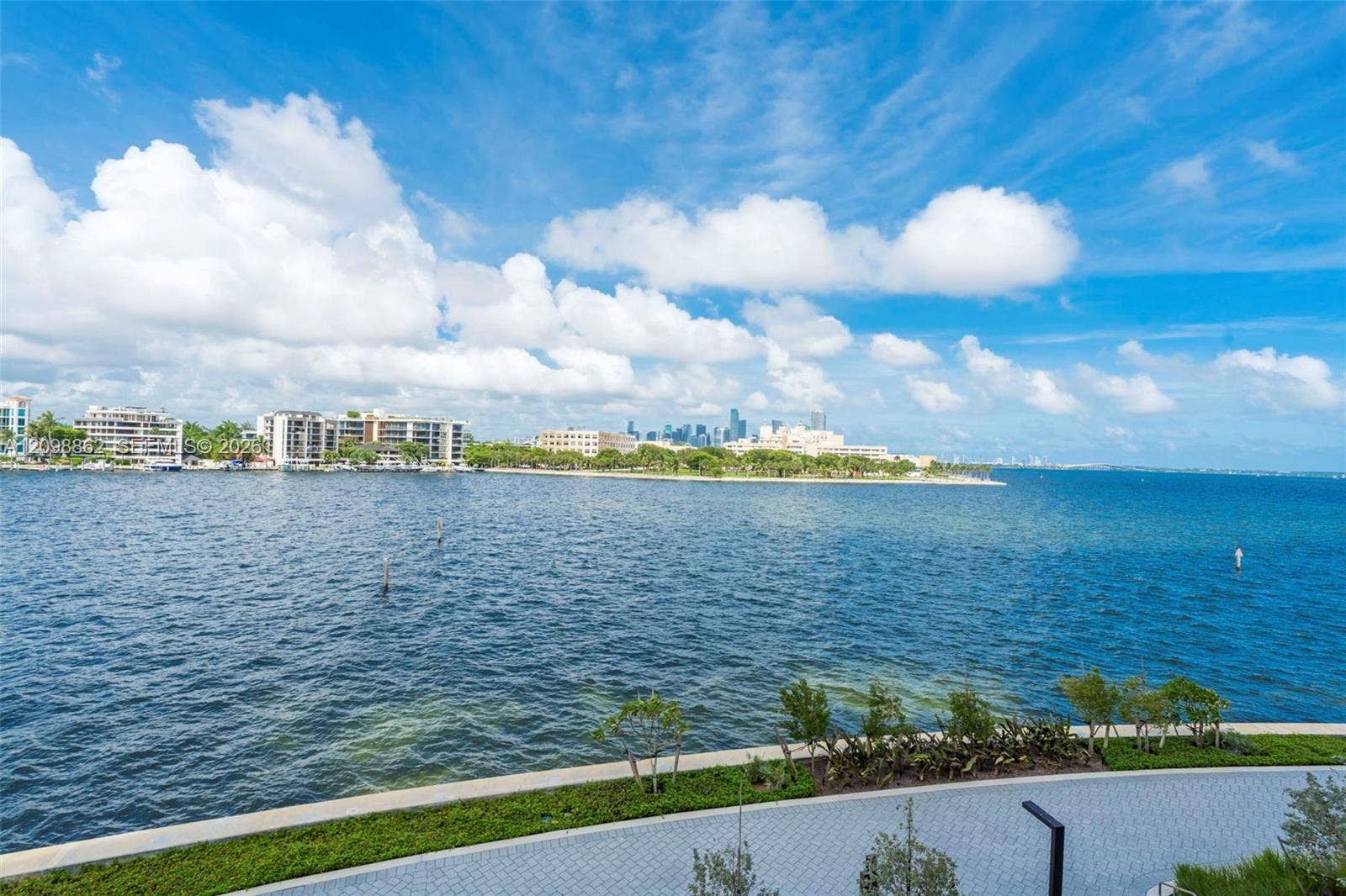 Waterfront location with direct bay frontage, stone-paver walkway, and manicured landscaping