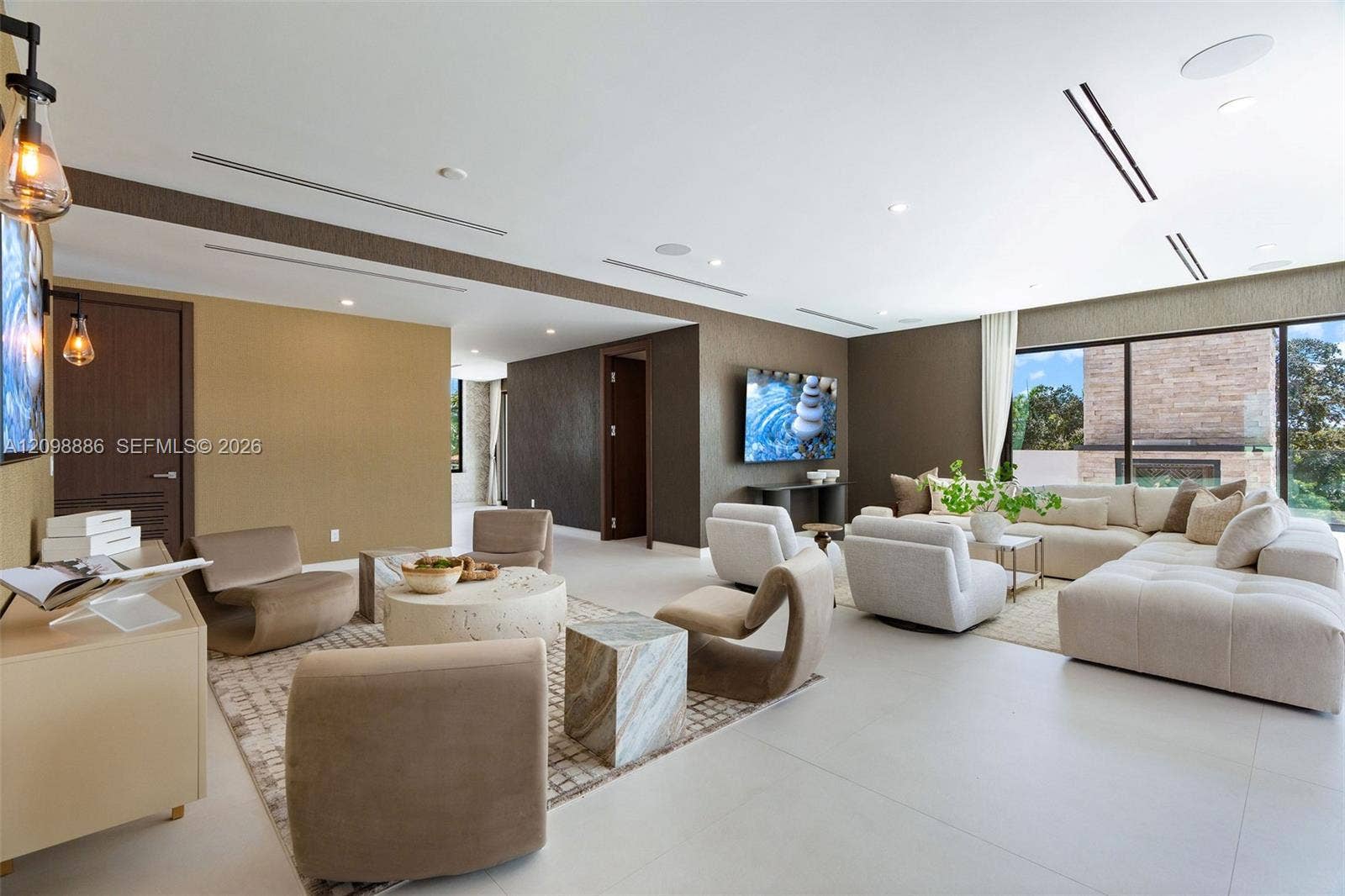 Large living area featuring large-format tile flooring, recessed ceiling lighting, linear HVAC diffusers, and sliding glass wall panels