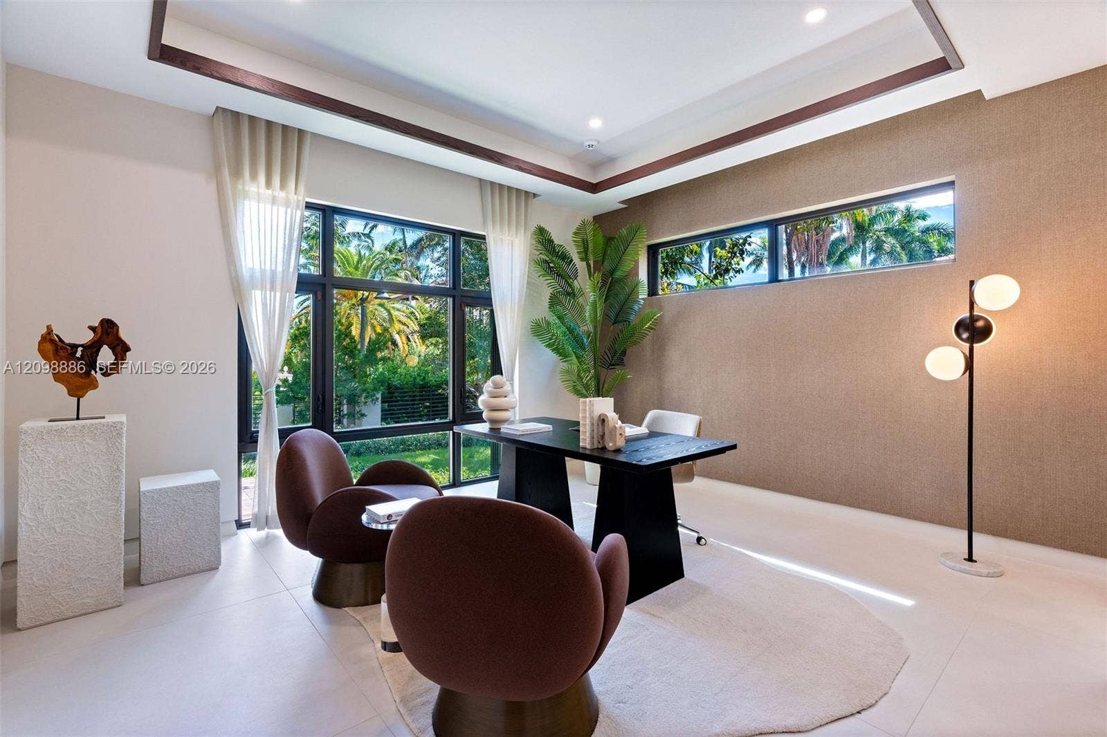 Tray ceiling with recessed wood-tone detailing, floor-to-ceiling multi-pane windows, expansive horizontal clerestory windows, and textured wall finish