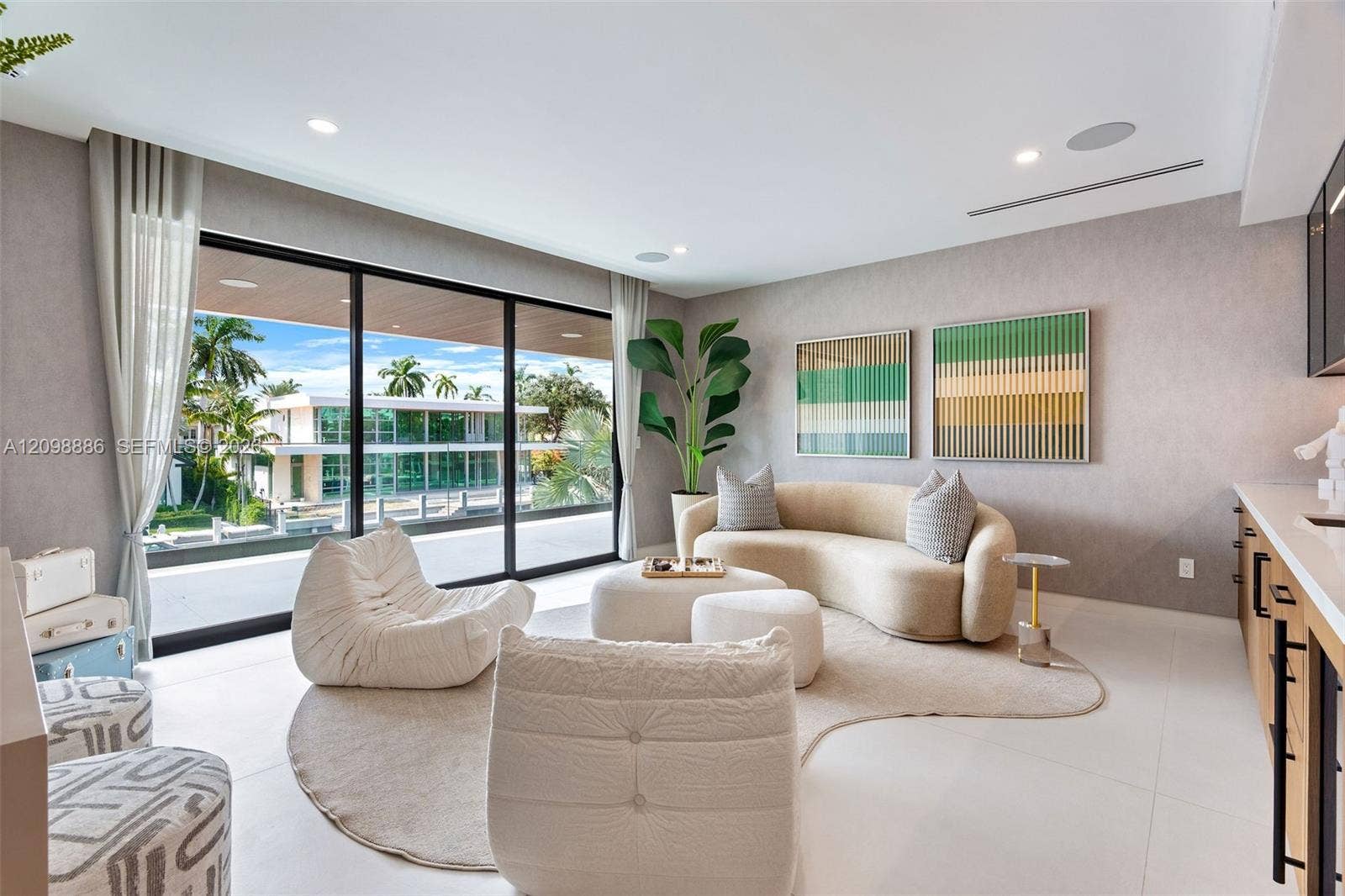 Floor-to-ceiling sliding glass walls, recessed ceiling lighting, light-toned oversized tile flooring, built-in cabinetry, and integrated ceiling speakers