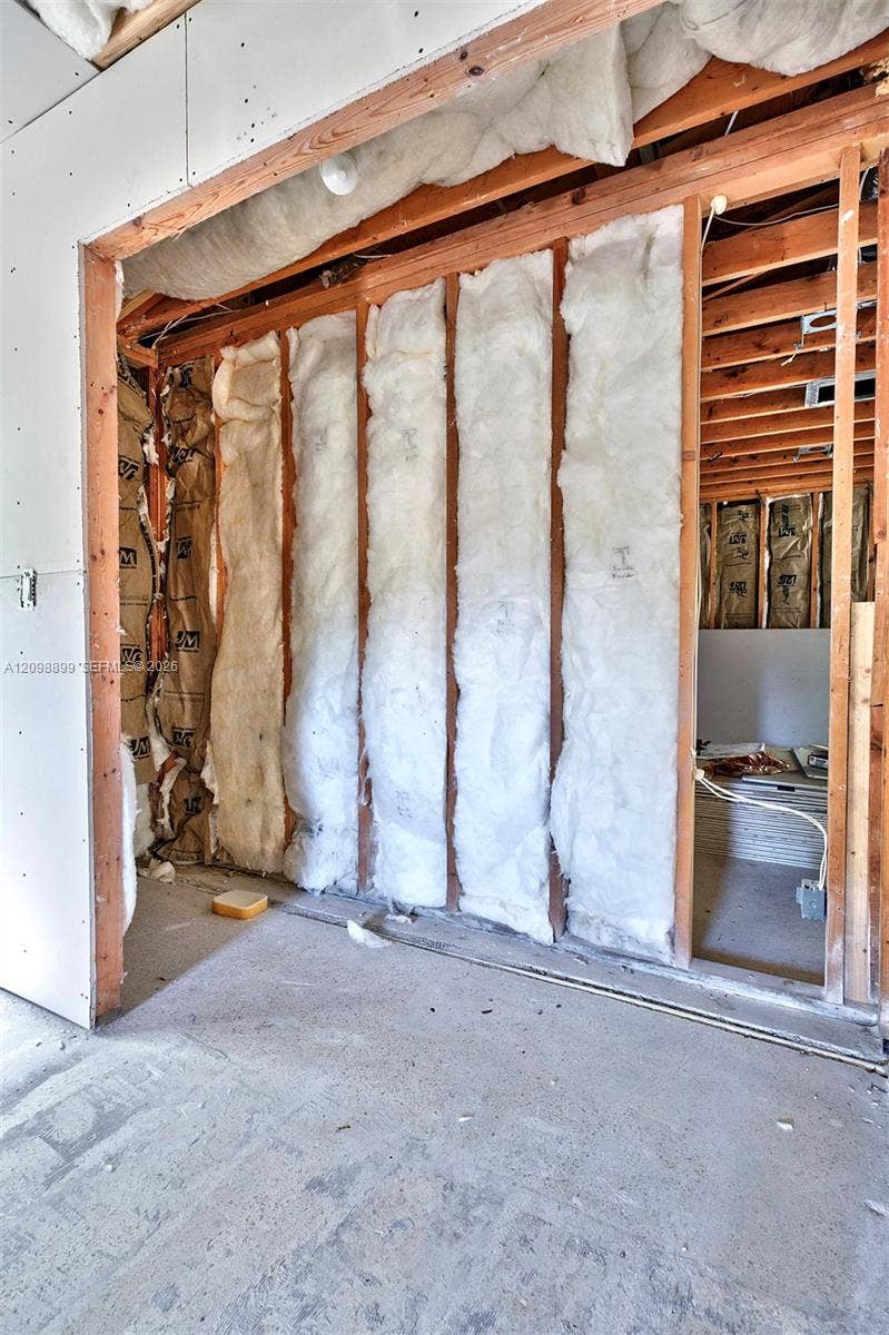 1176 SW 4th Street, Boca Raton, FL 33486 Interior space featuring exposed wood framing, installed fiberglass batt insulation, and unfinished wall surfaces