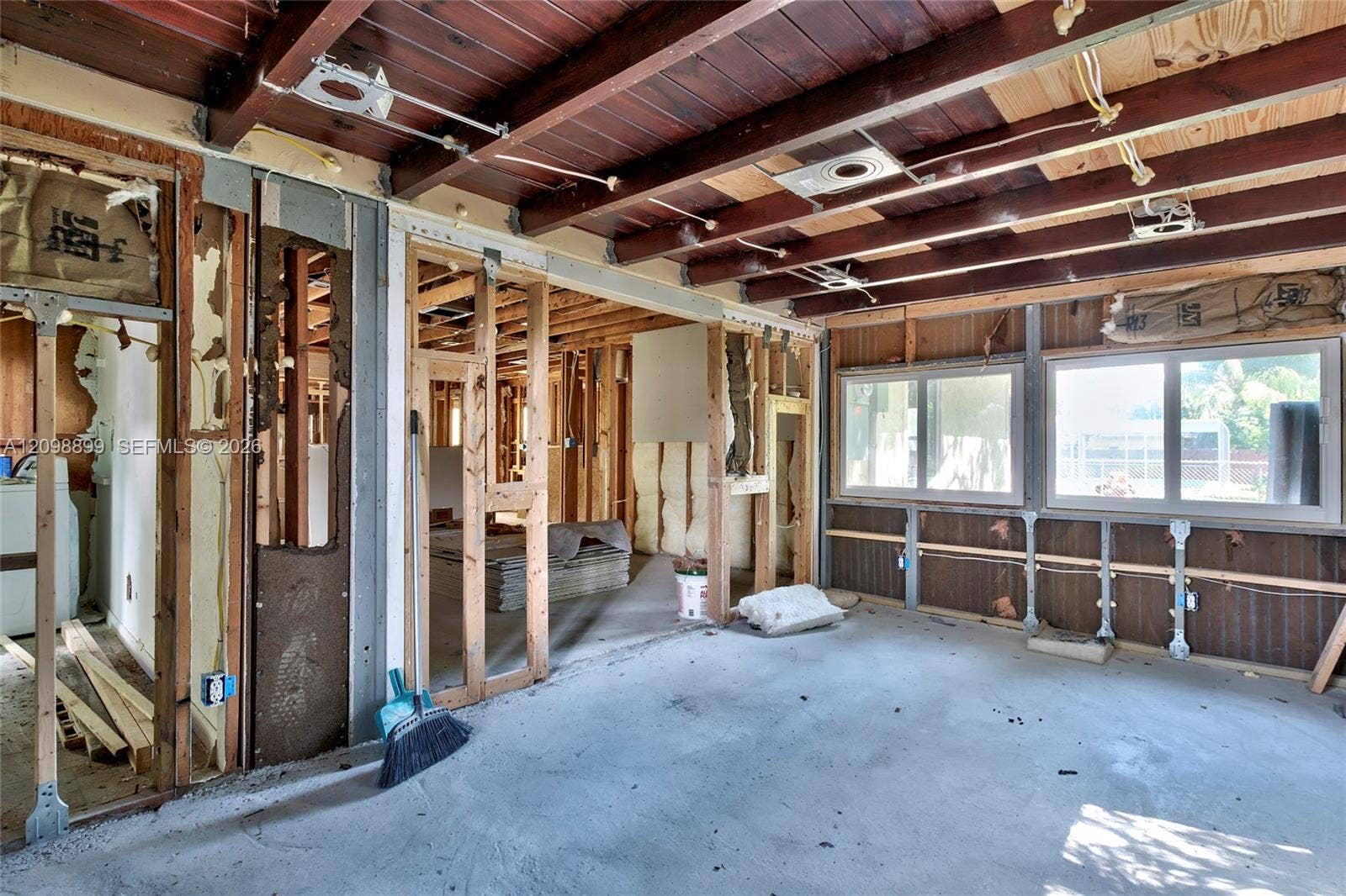 1176 SW 4th Street, Boca Raton, FL 33486 Open-concept interior featuring exposed wood beam ceilings, structural wall framing, and large double-pane windows